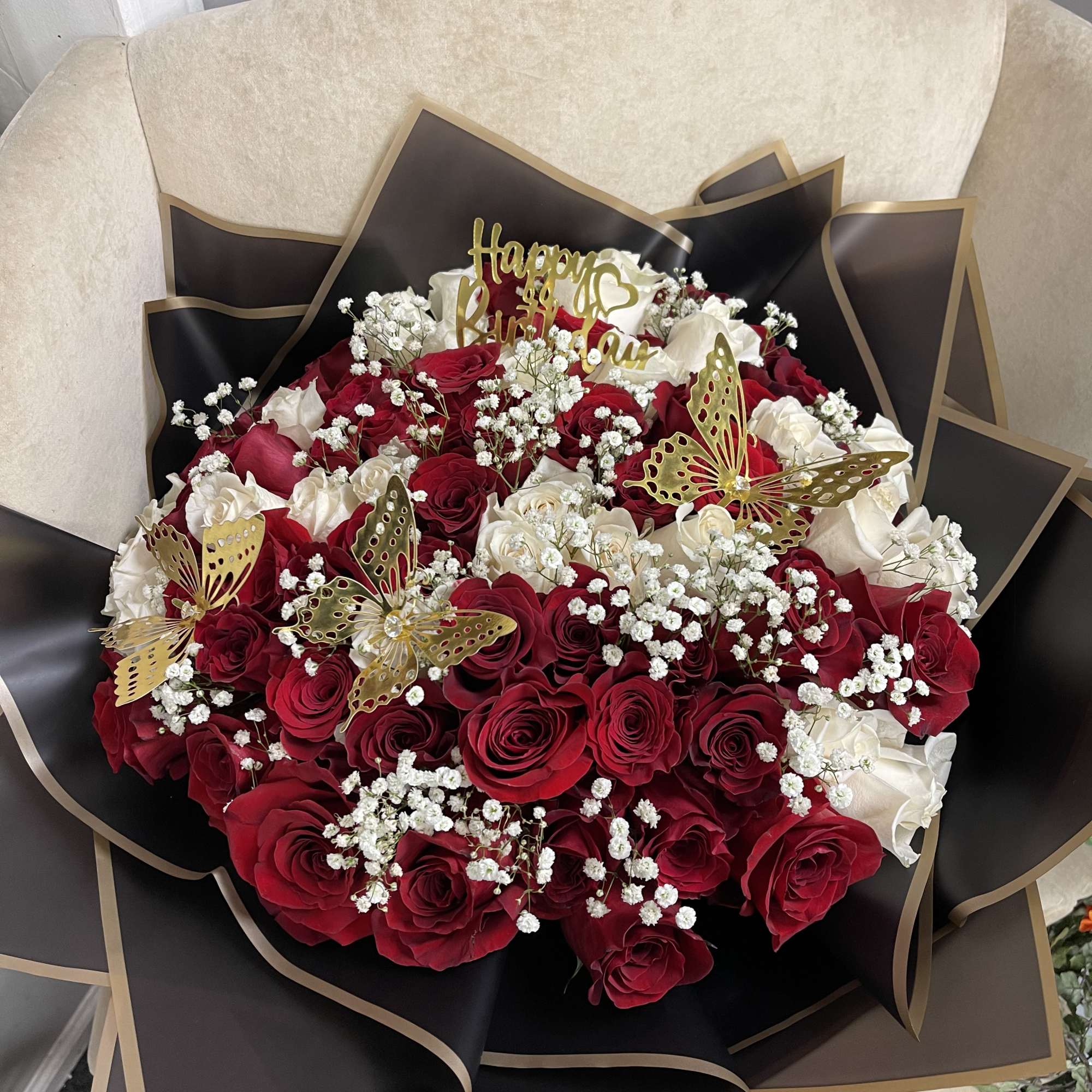 Bouquet of red and white roses with gold butterfly accents