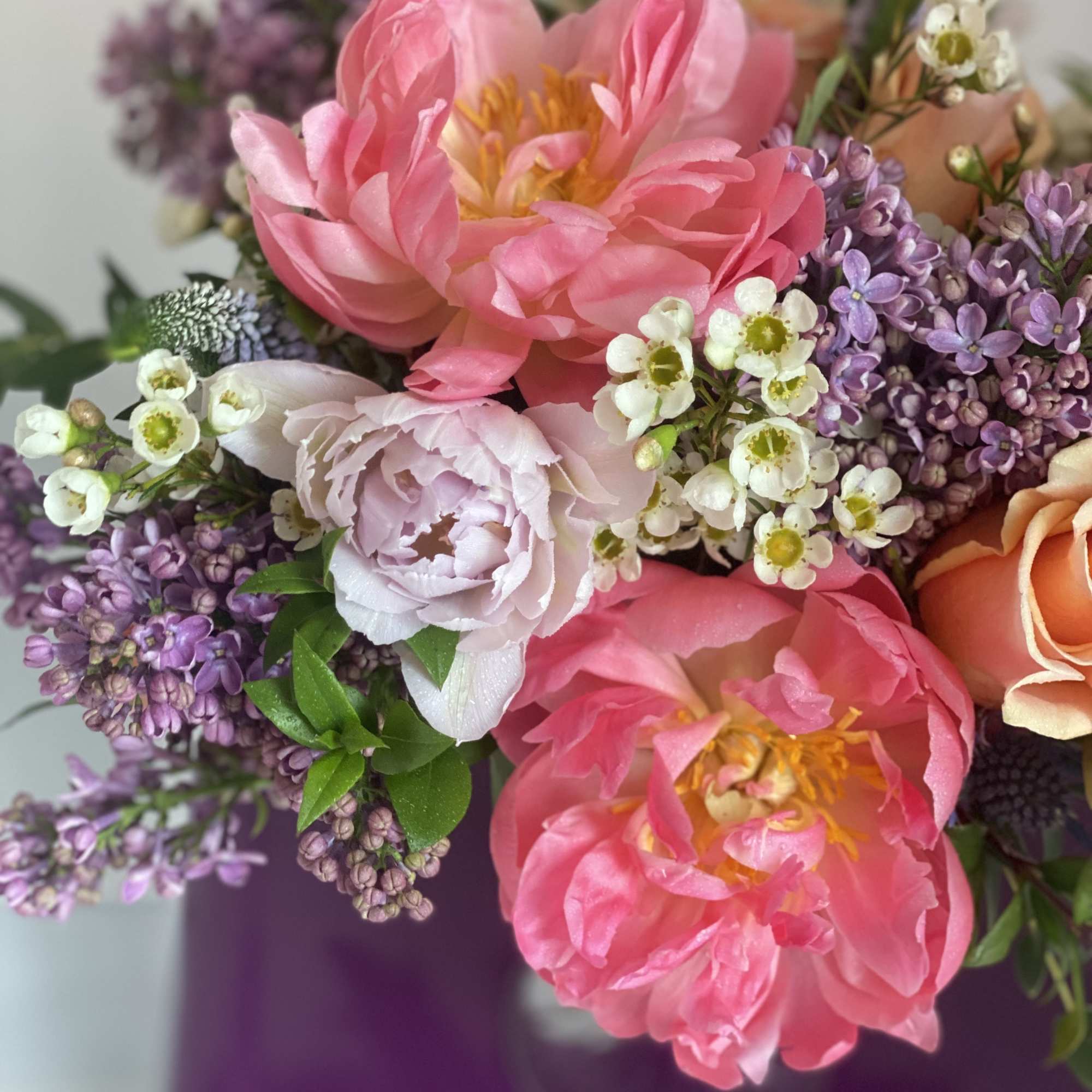 Pink peonies and purple lilacs in a vase