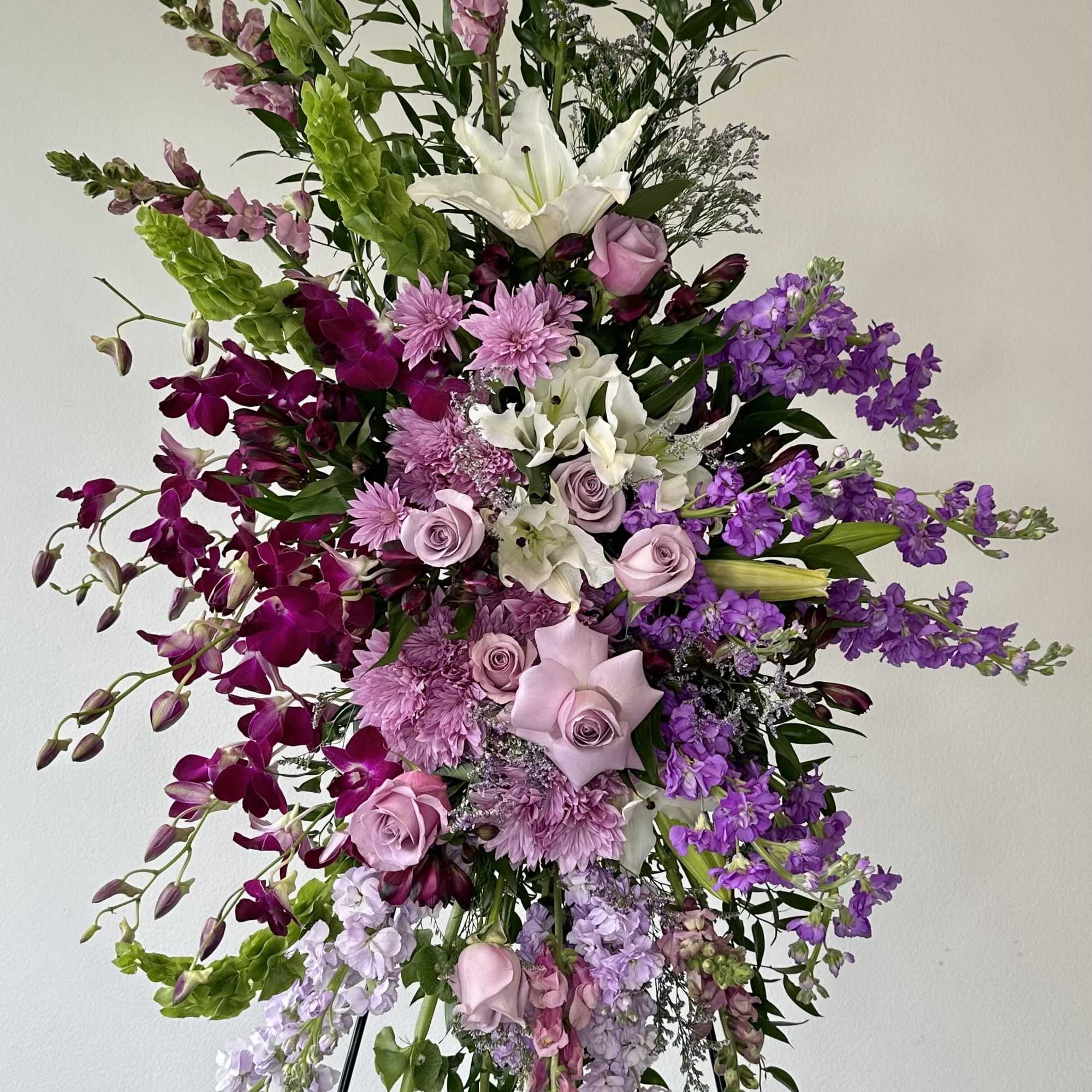 Tall floral spray with purple, pink, and white flowers on an easel