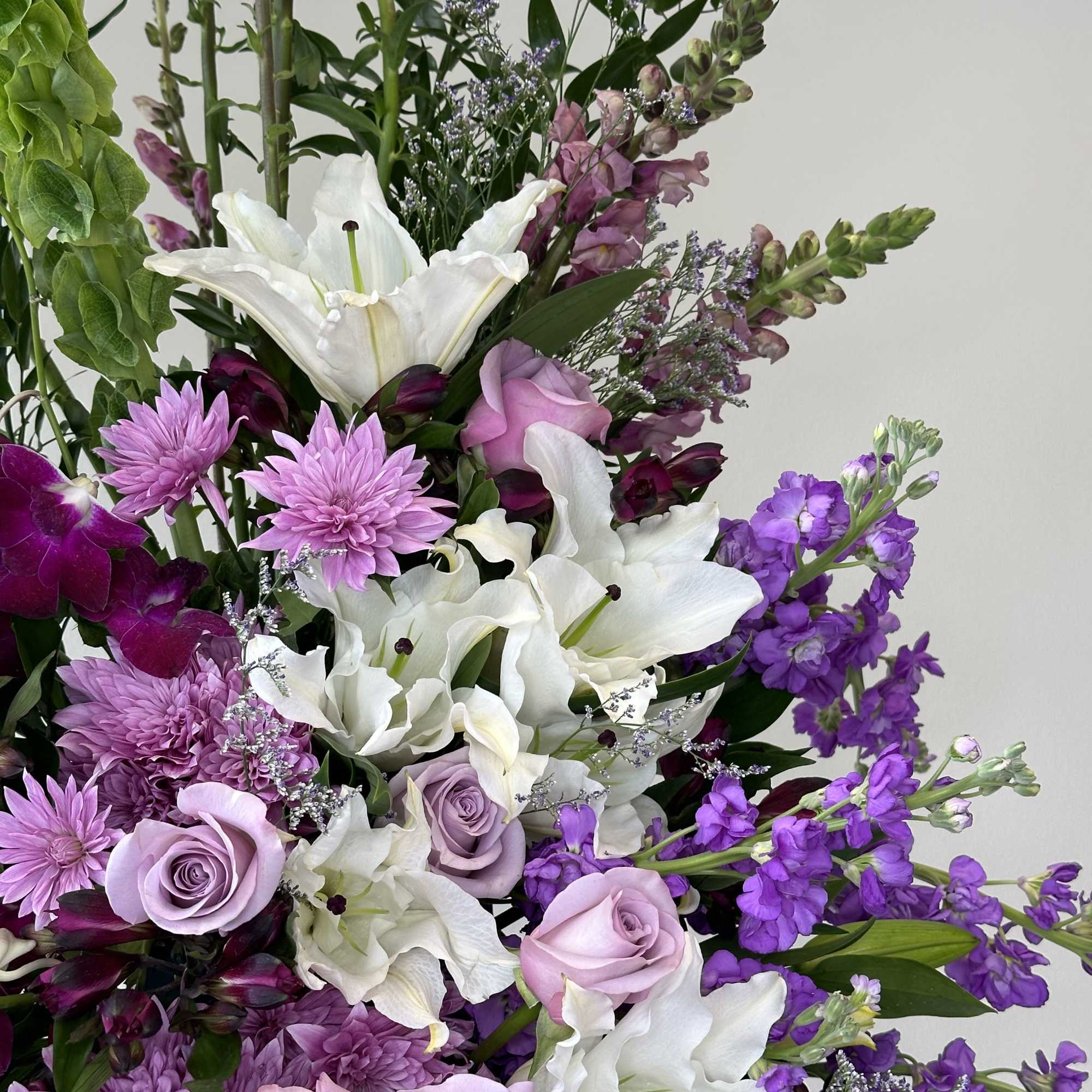 Bouquet of white lilies, lavender roses, and purple flowers