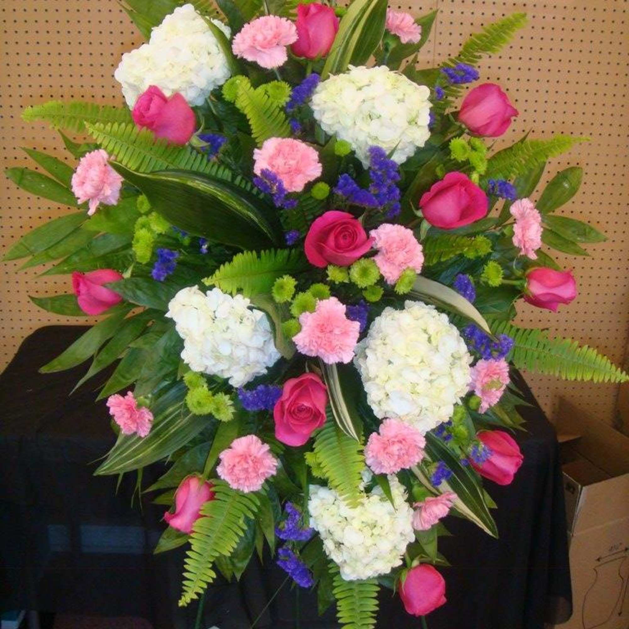 Standing floral spray with pink roses, white hydrangeas, and carnations