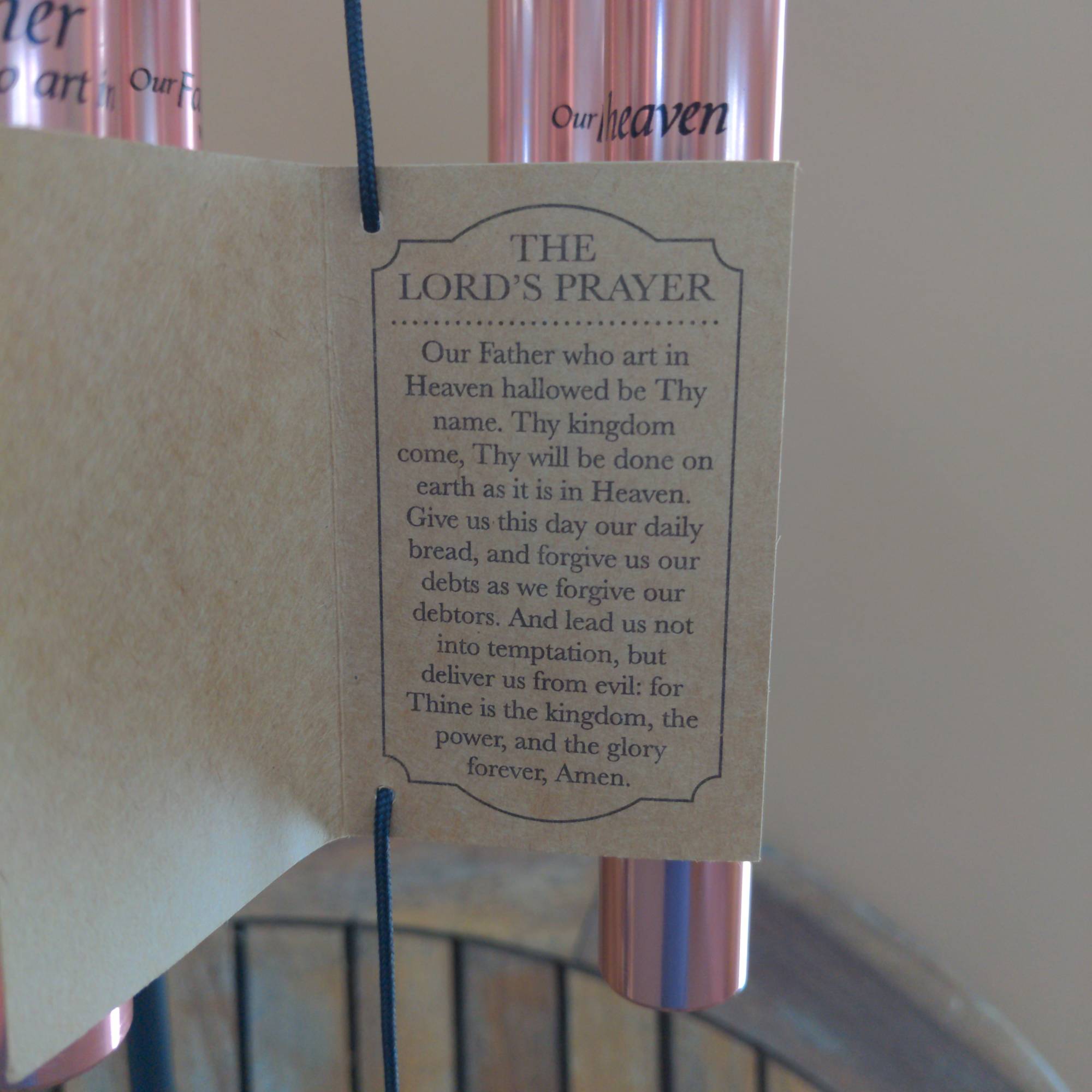 Prayer card hanging from pink wind chimes