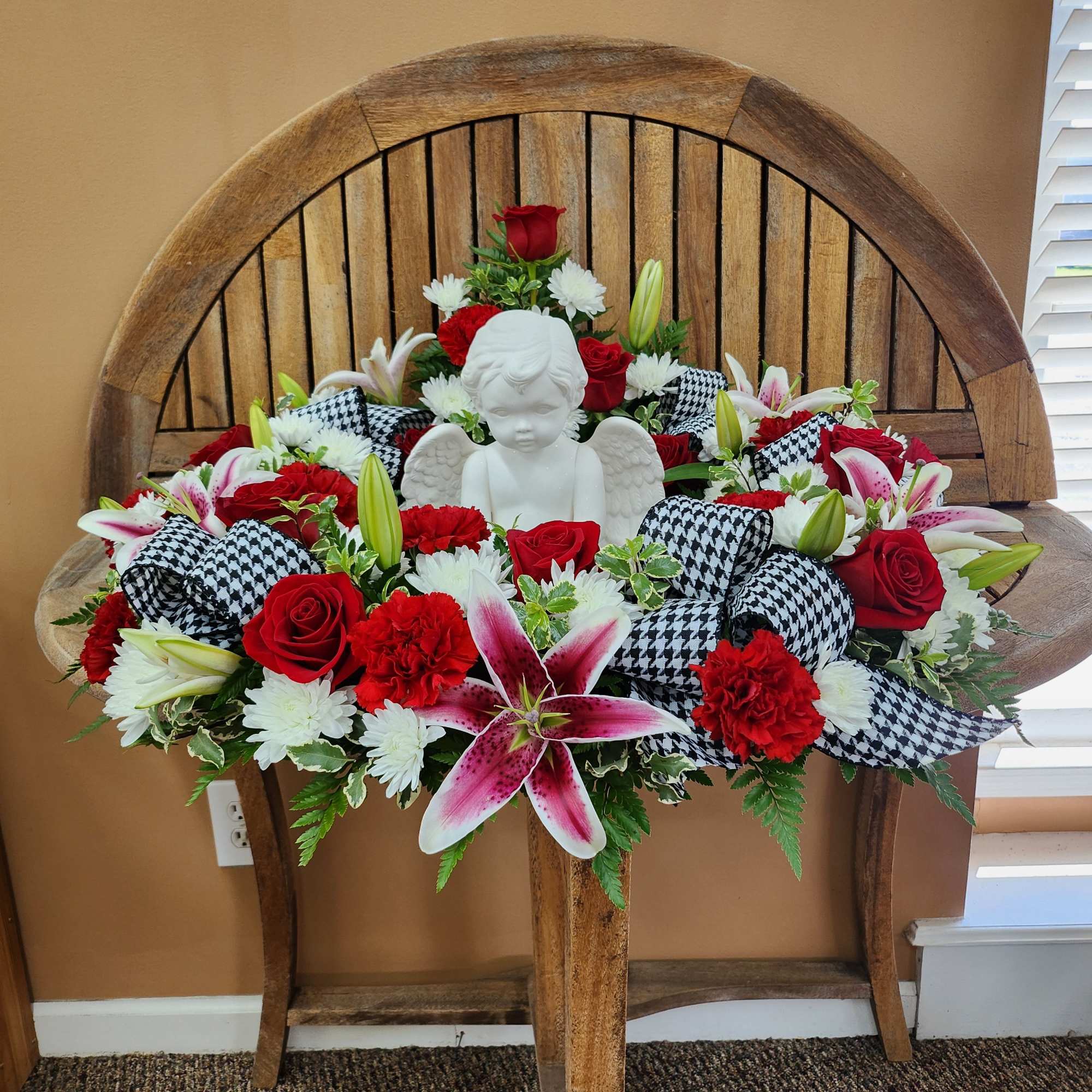 Red and white floral arrangement with a white angel figurine