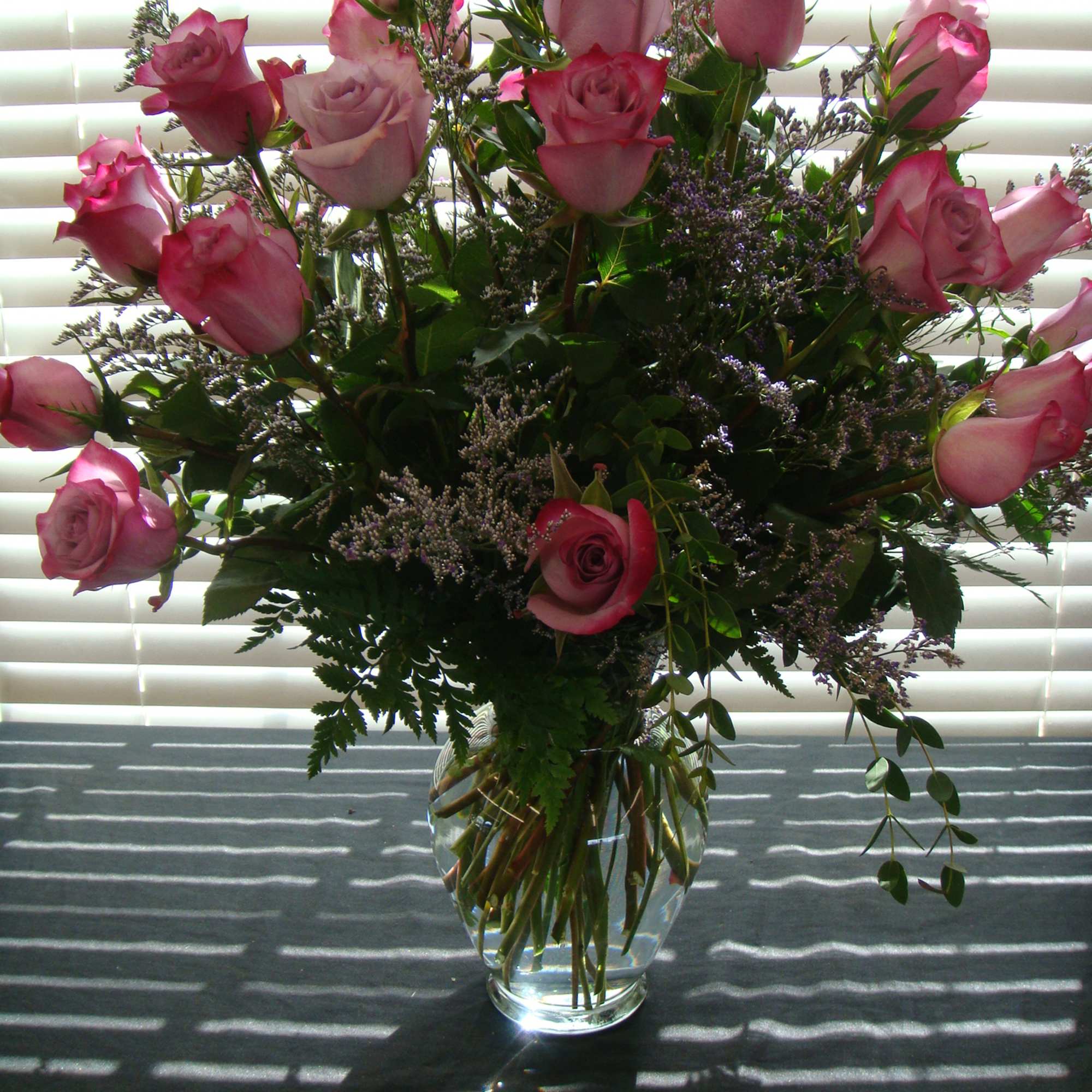 Pink roses arranged in a clear glass vase