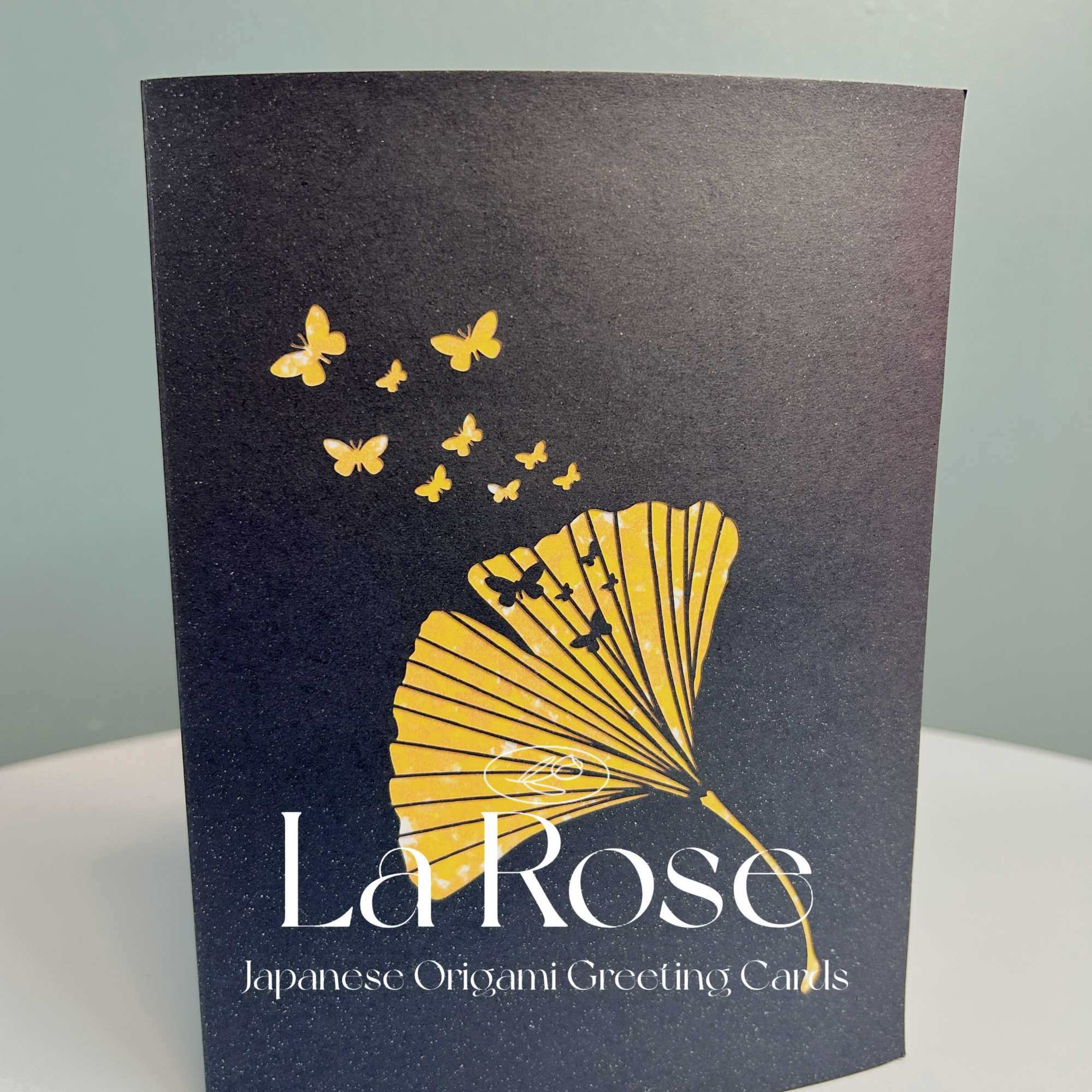 Black greeting card with a gold fan and butterflies