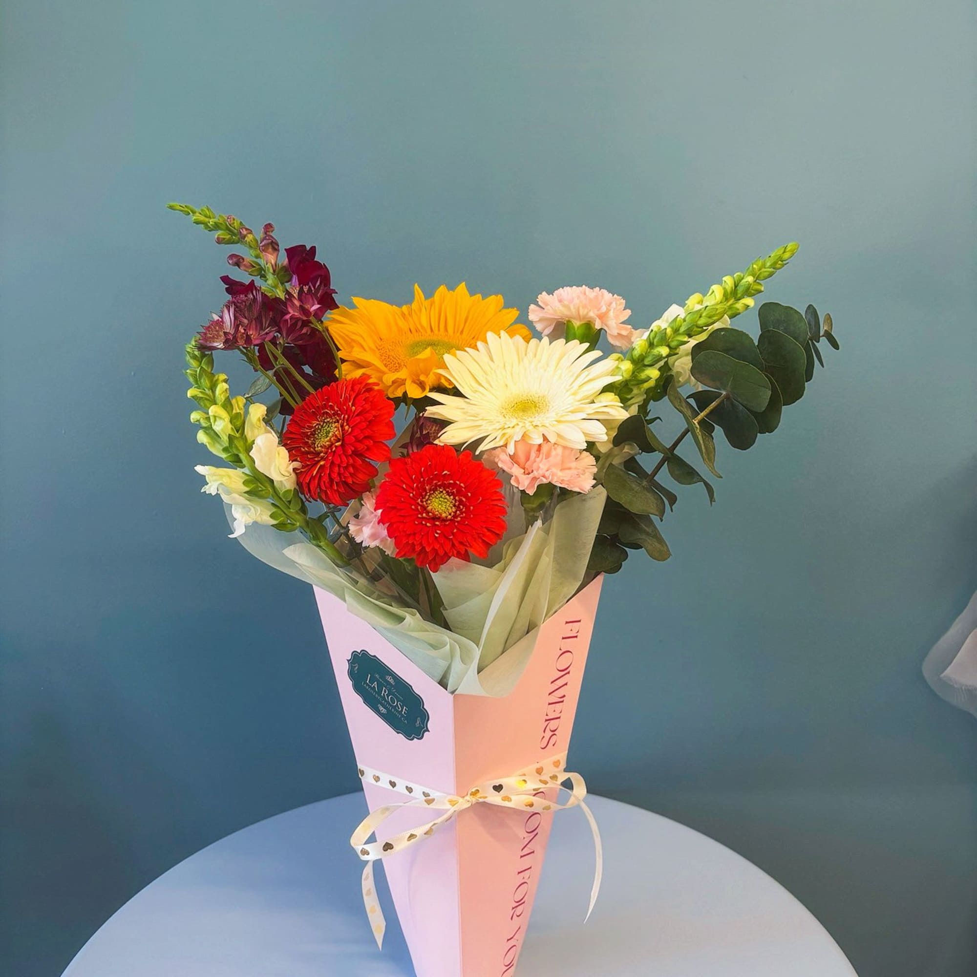 Mixed bouquet with gerbera daisies and carnations in a pink wrap