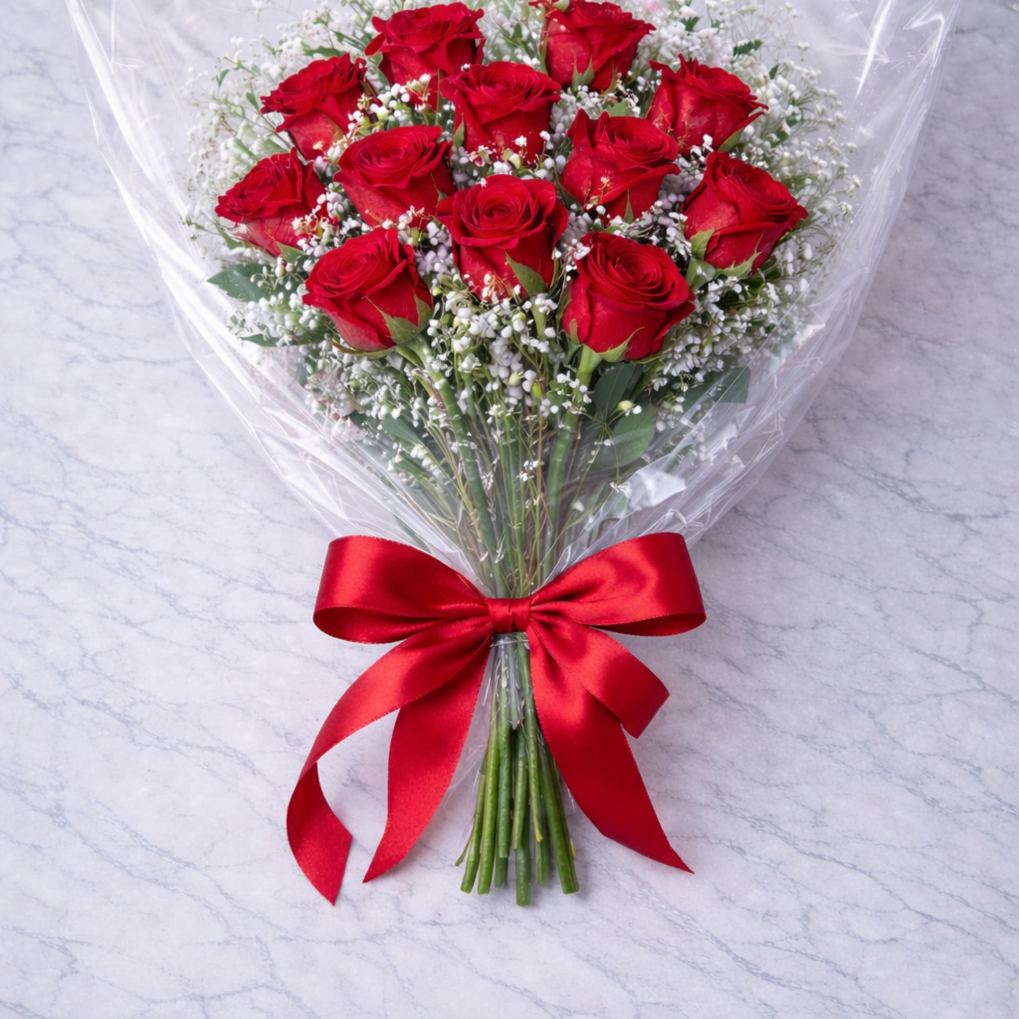 Bouquet of red roses wrapped in clear plastic with a red ribbon