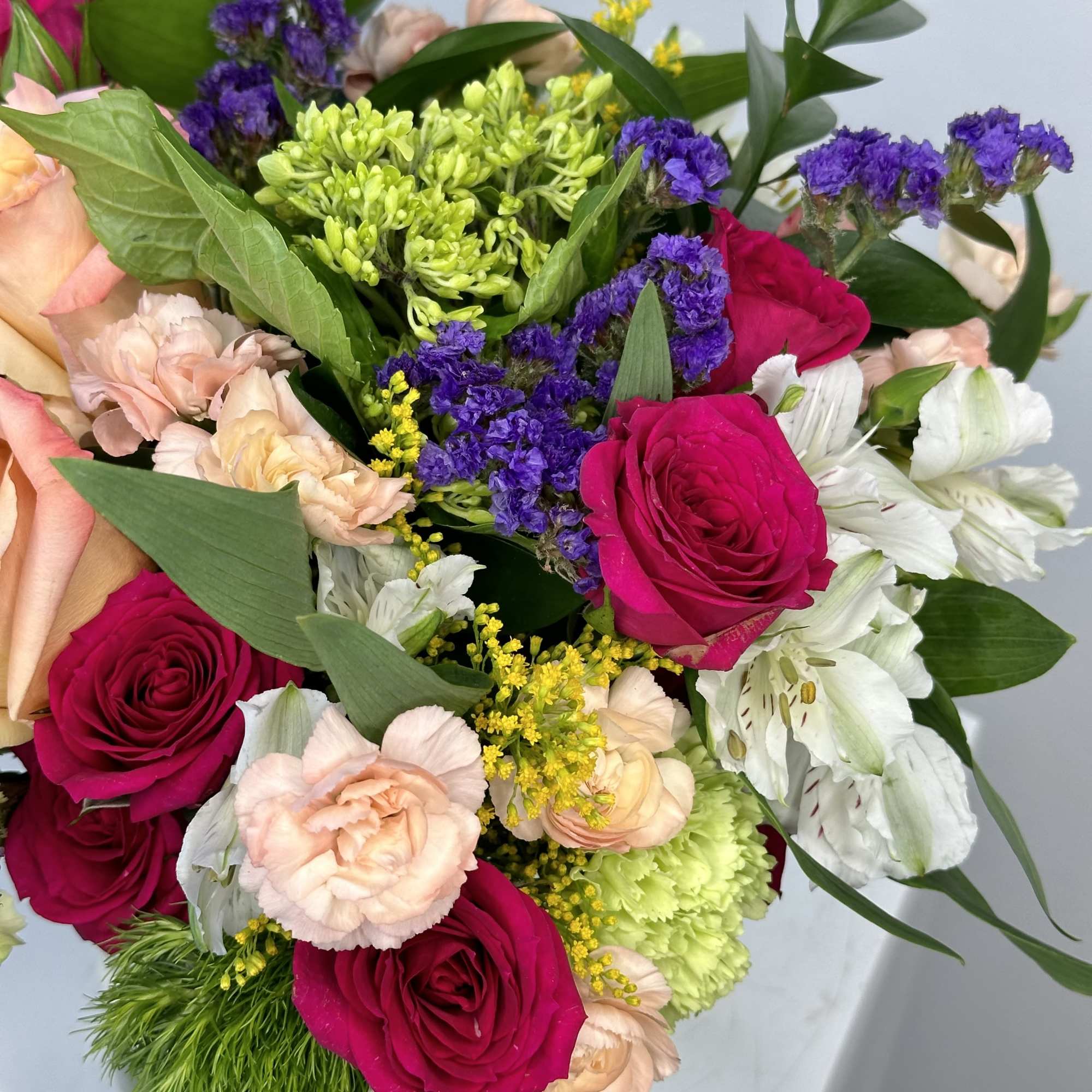 Bouquet of hot pink roses, pale carnations, and white alstroemeria