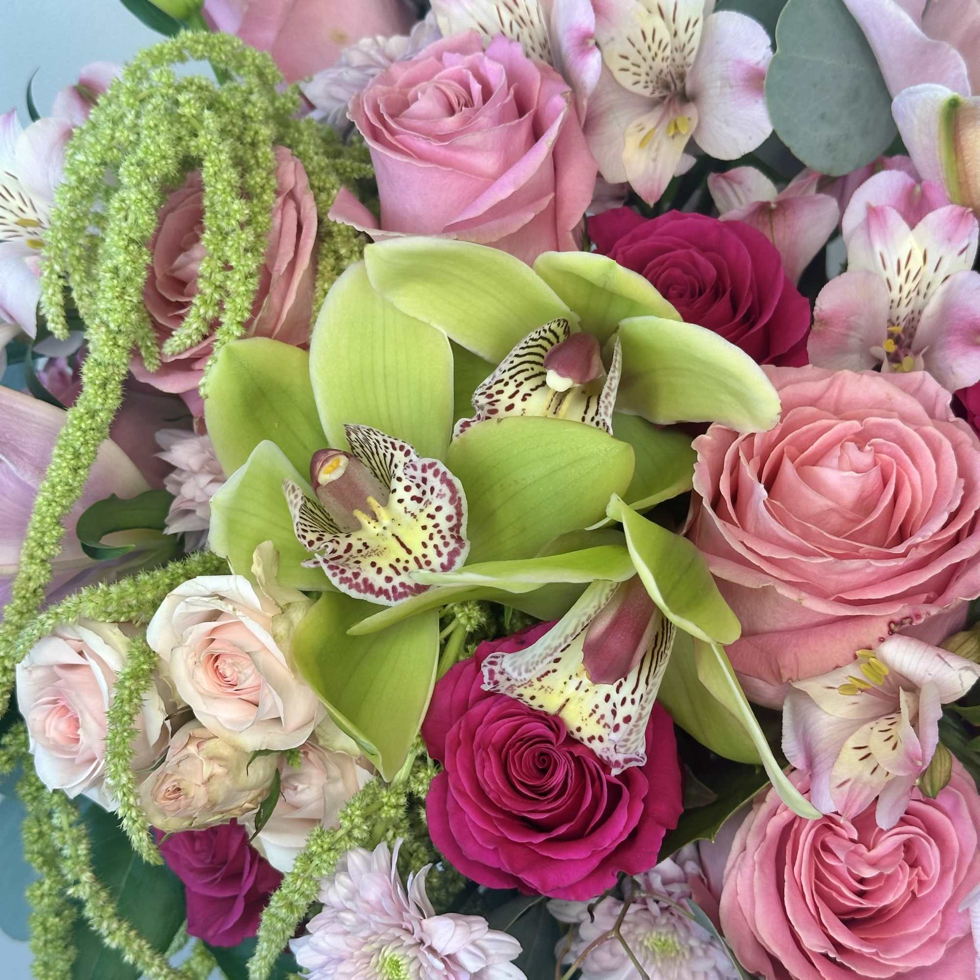 Pink roses and green orchids in a mixed bouquet