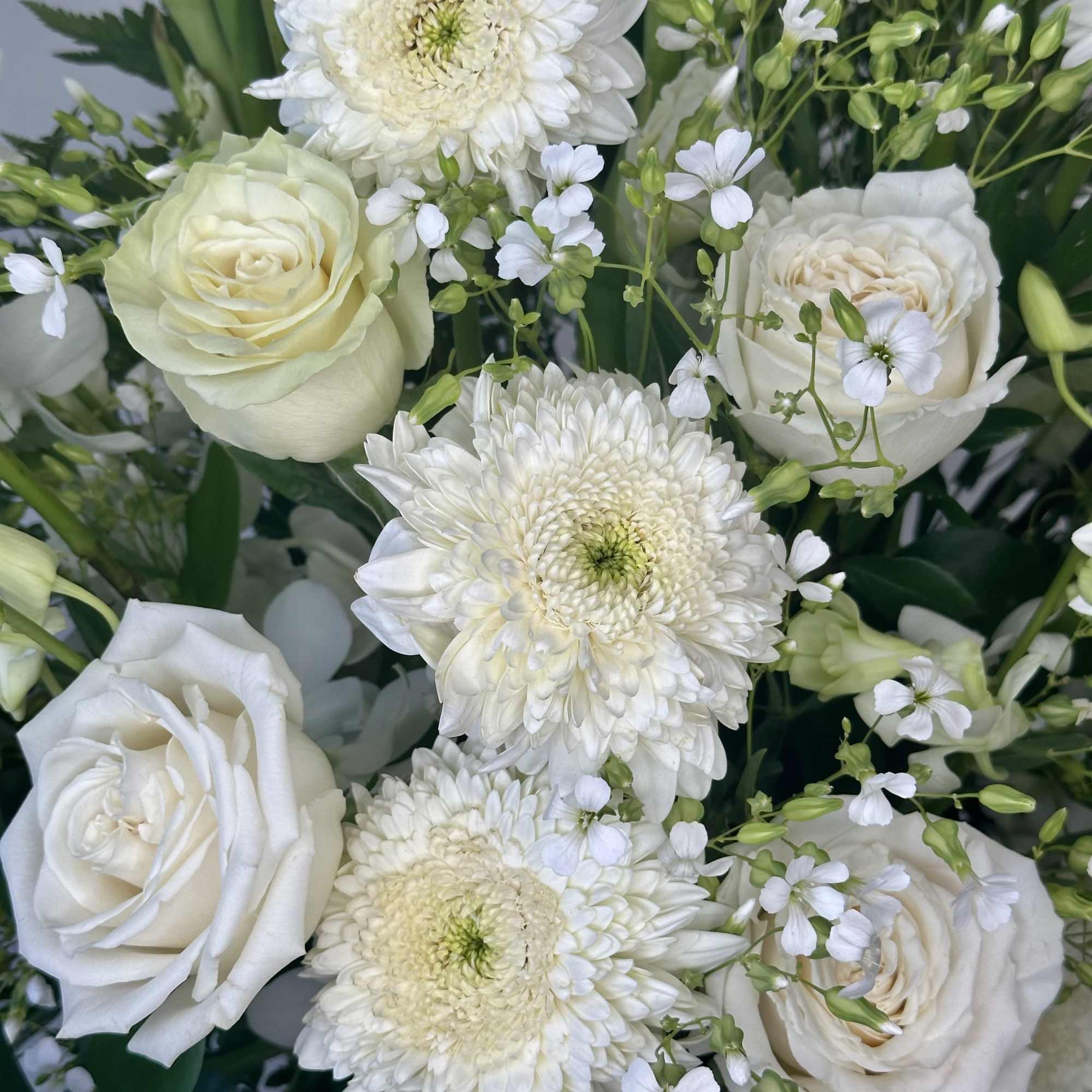 White roses and chrysanthemum blooms in a dense bouquet