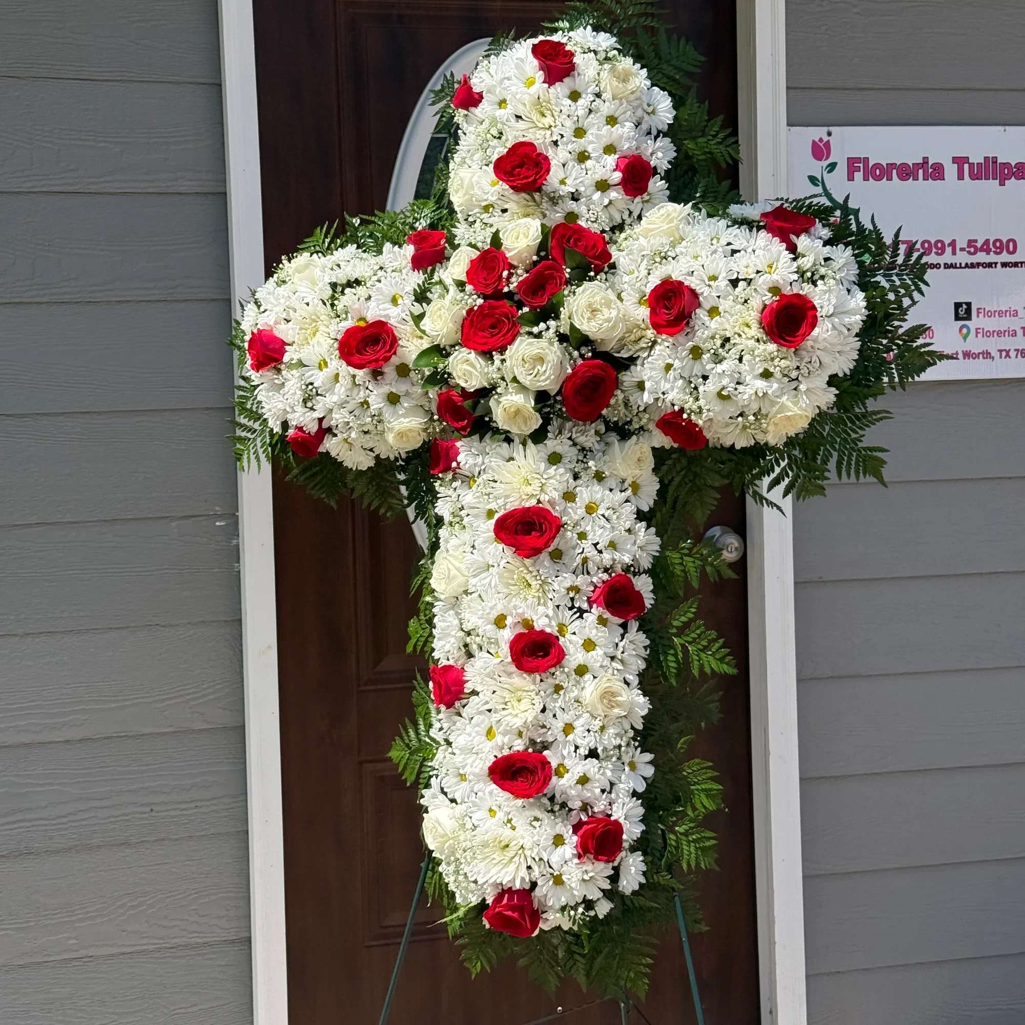 Hermosa cruz floral elaborada con rosas rojas, rosas blancas y delicados crisantemos