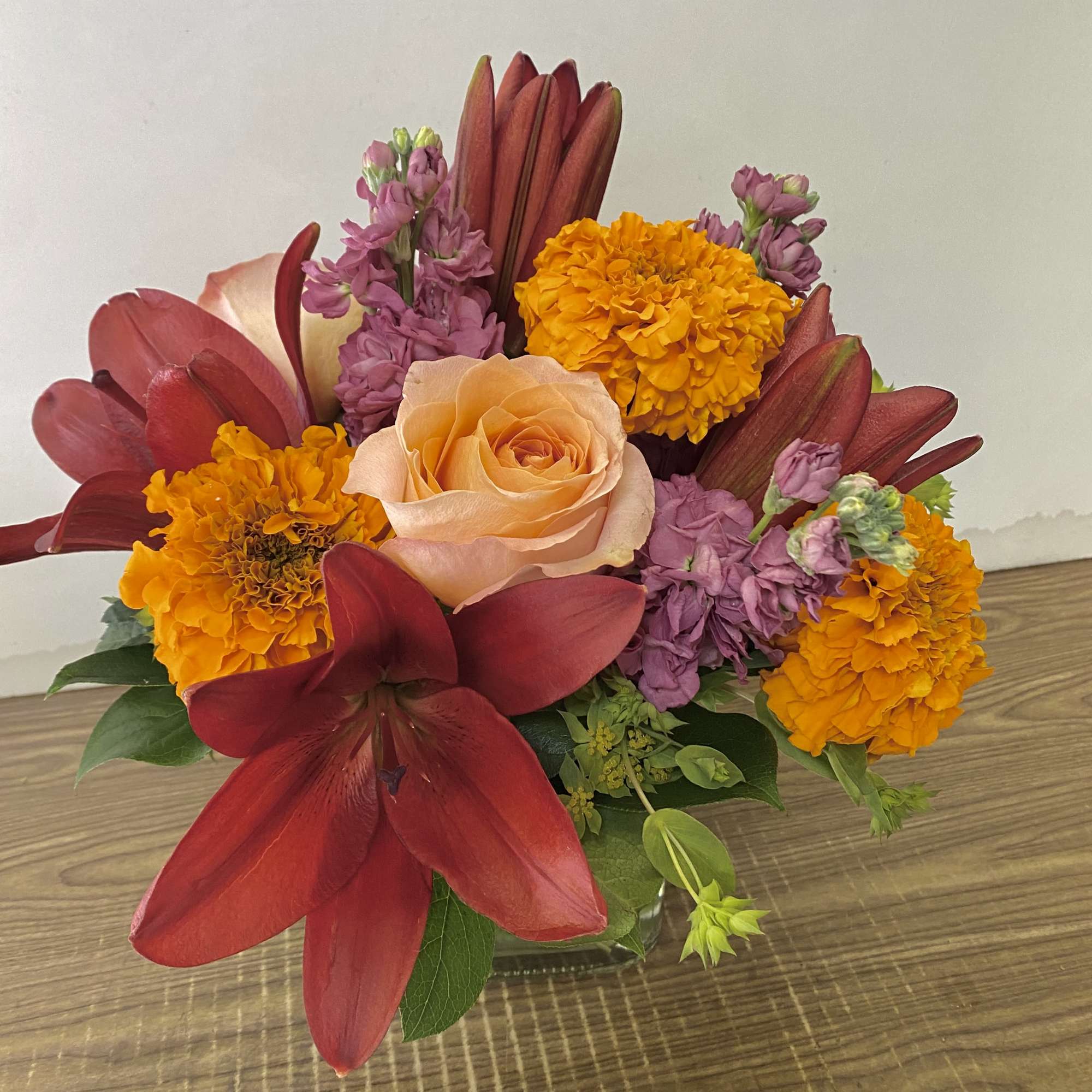 In the clear glass, square vase combinations or orange flowers lilies, marigold