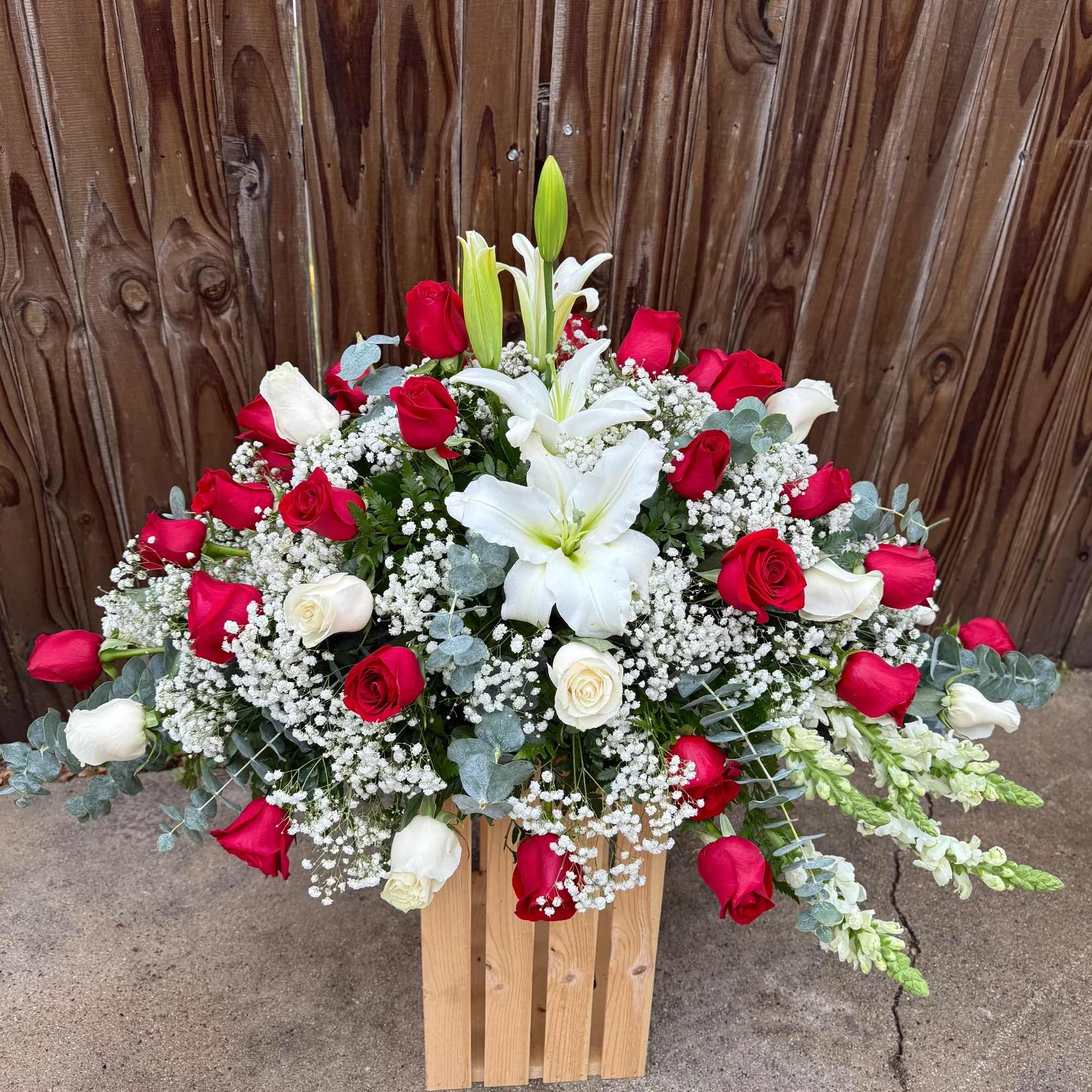 Hermoso arreglo floral elaborado con delicadas rosas rojas y blancas, acompa&ntilde;ado de
