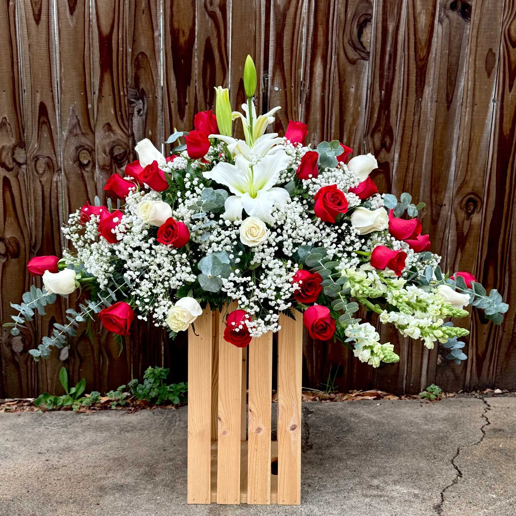 Hermoso arreglo floral elaborado con delicadas rosas rojas y blancas, acompa&ntilde;ado de