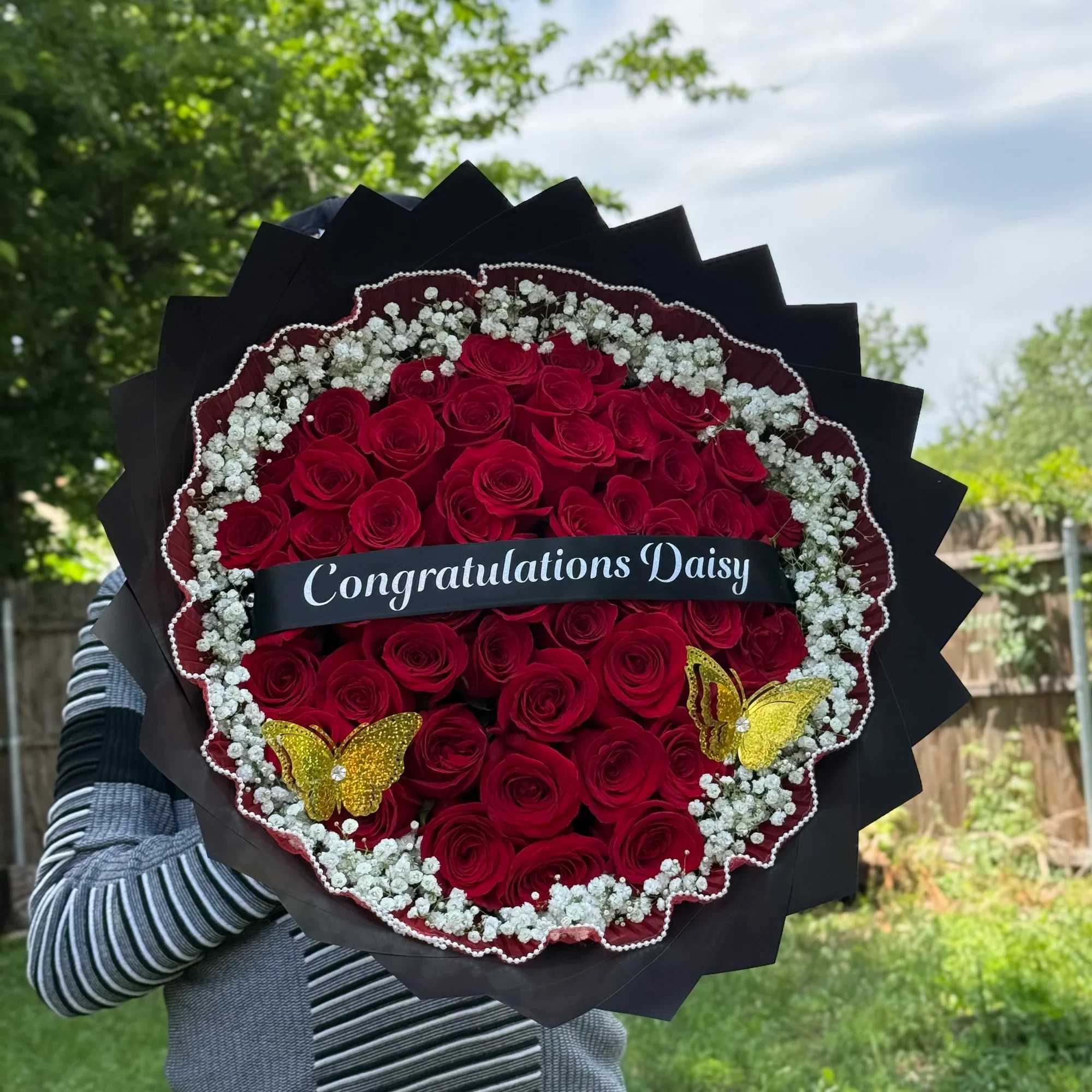 Un elegante ramo de rosas rojas premium decorado con delicadas flores blancas