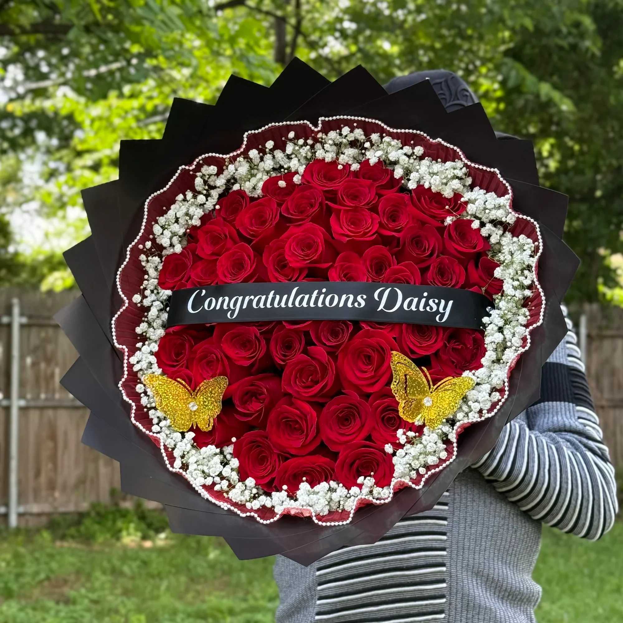 Un elegante ramo de rosas rojas premium decorado con delicadas flores blancas