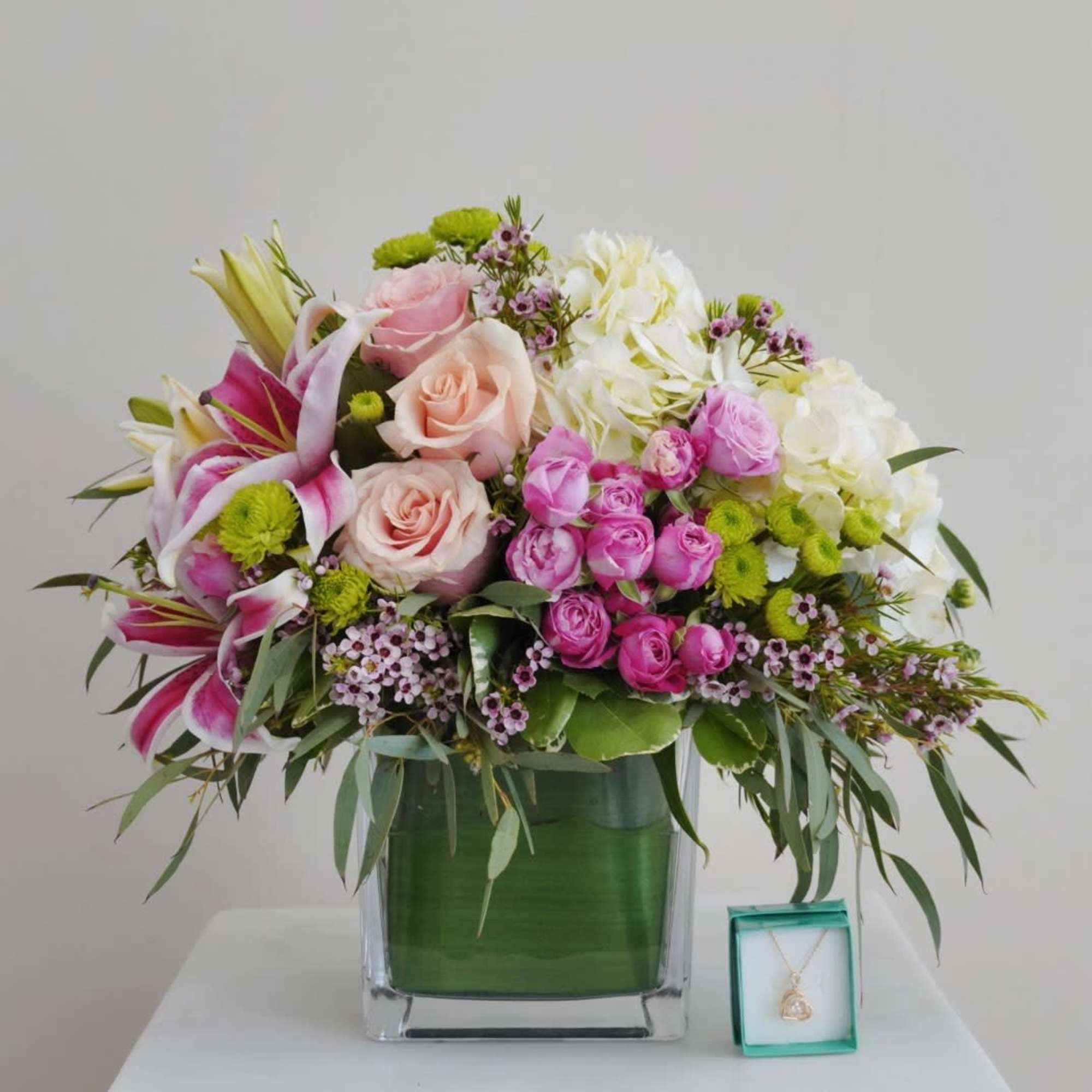 Bright clusters of pink roses and white lilies create a lush, romantic