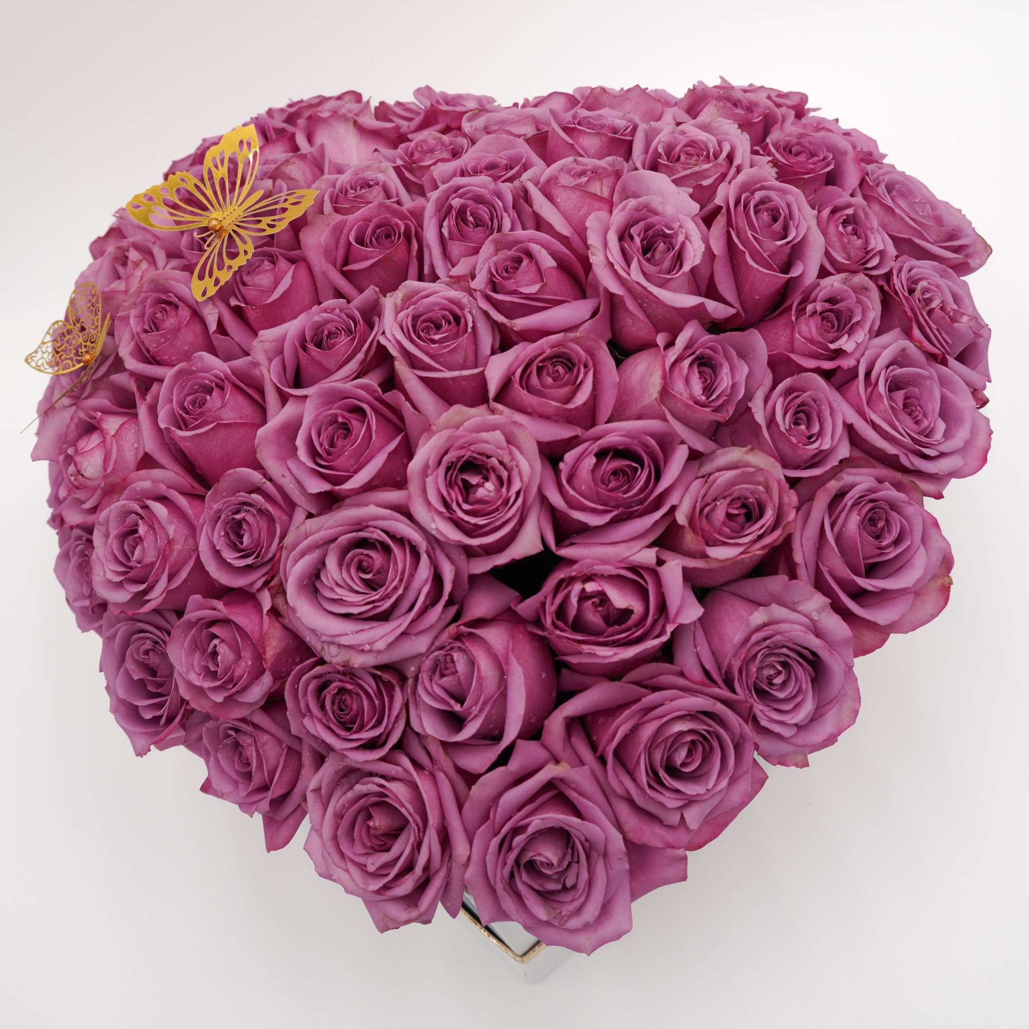 A dense heart-shaped box filled with 70 premium lavender roses creates an