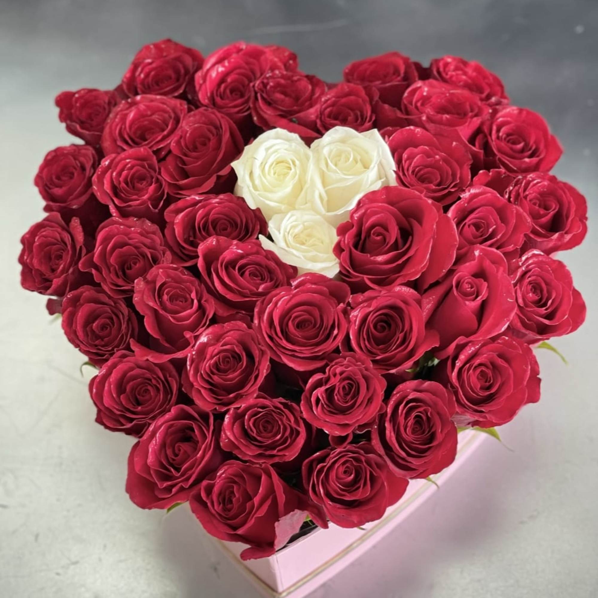 A bold heart-shaped display of 50 fresh roses makes an unforgettable anniversary