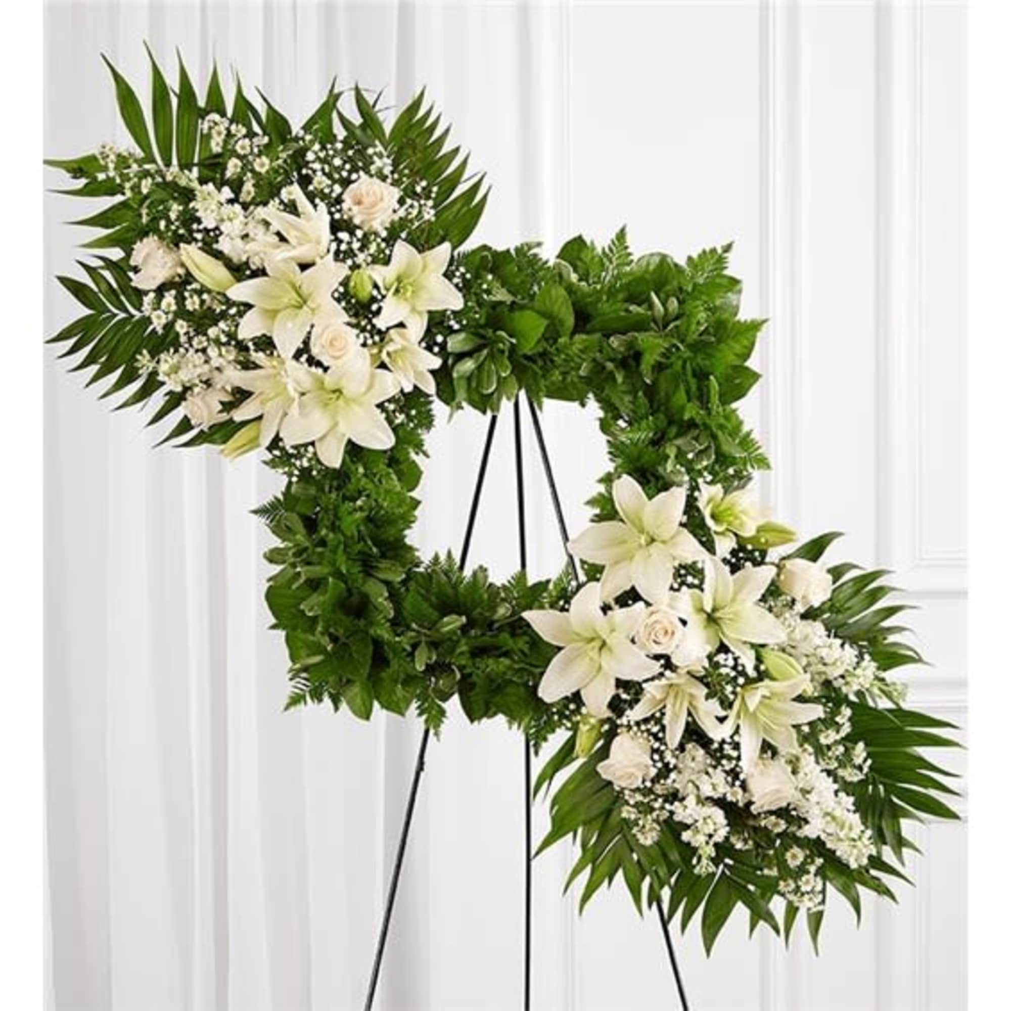 White floral funeral wreath on a black stand