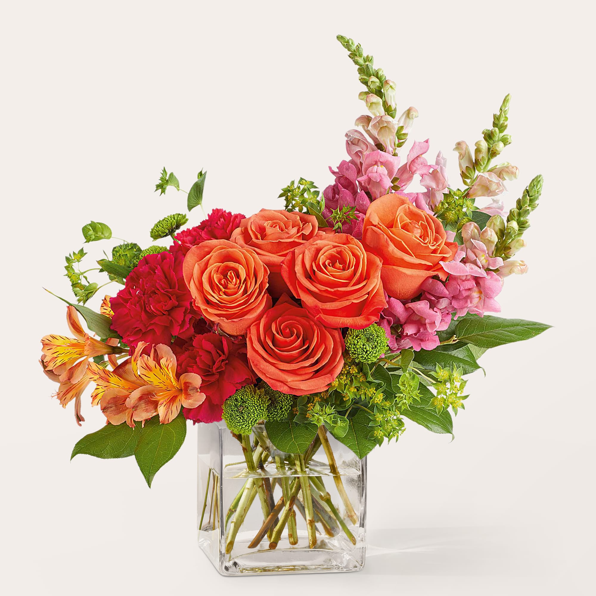 A vibrant mix of orange roses, pink snapdragons, red carnations, and bright