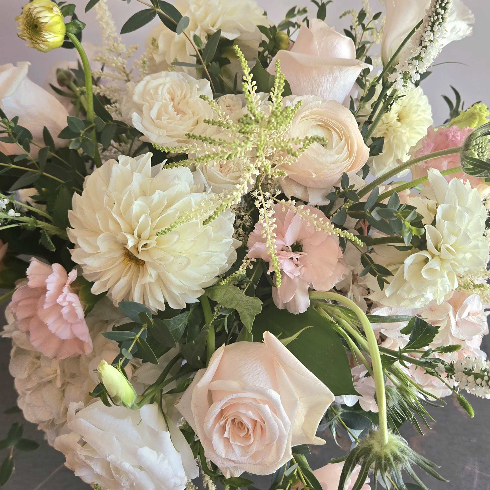 A lovely bright white and pink display filled with roses, dahlias, and