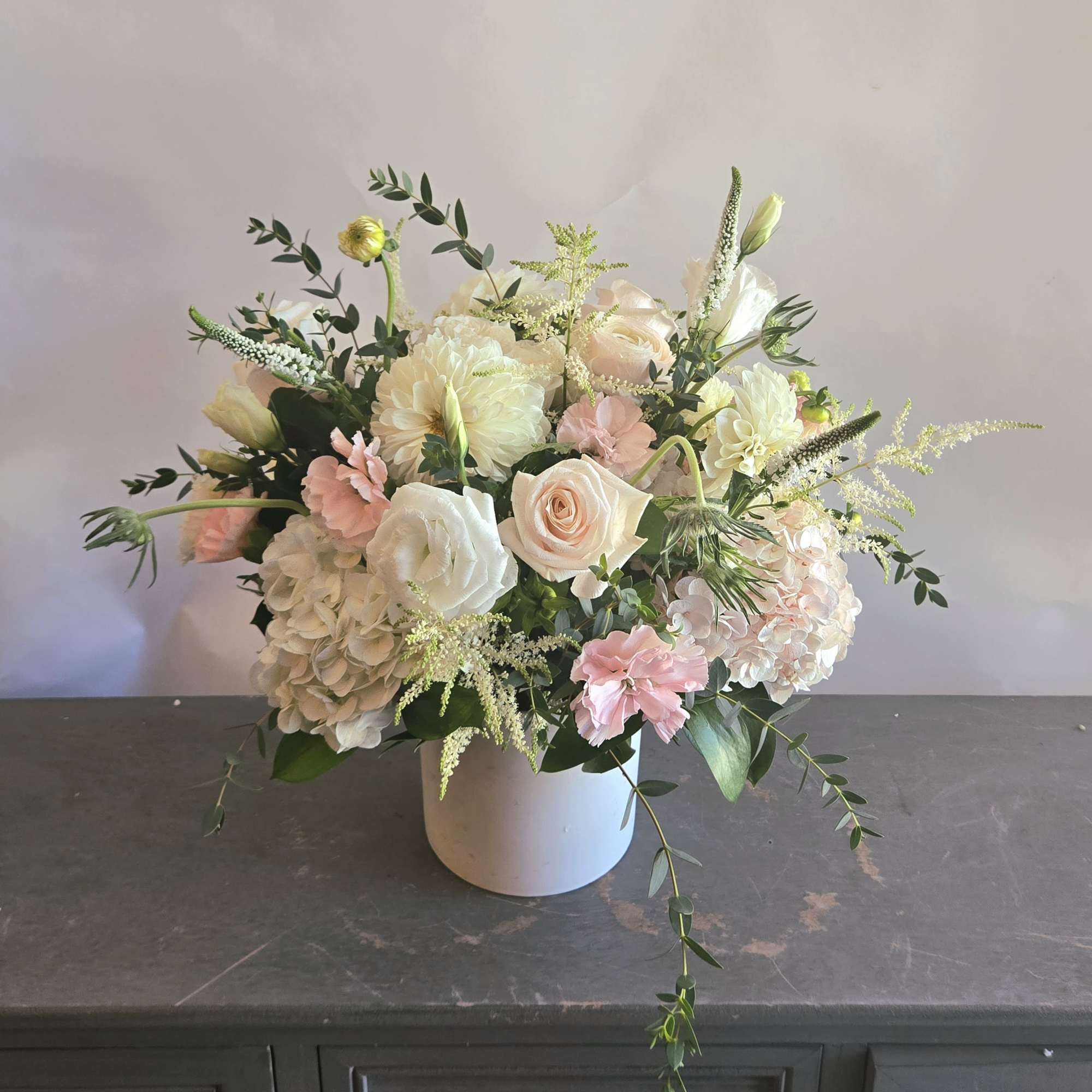 A lovely bright white and pink display filled with roses, dahlias, and