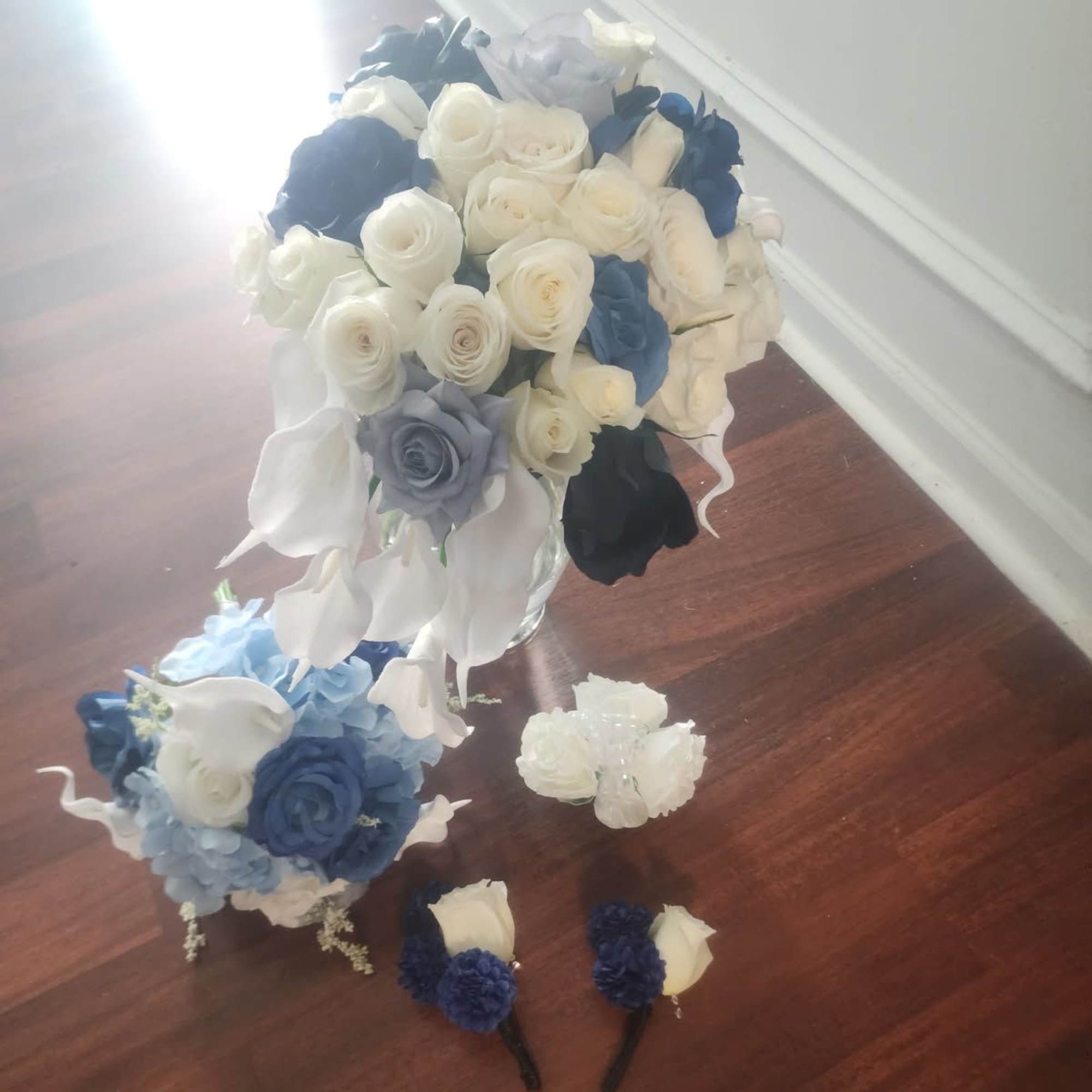 Bouquet of white, blue, and black roses with matching boutonnieres