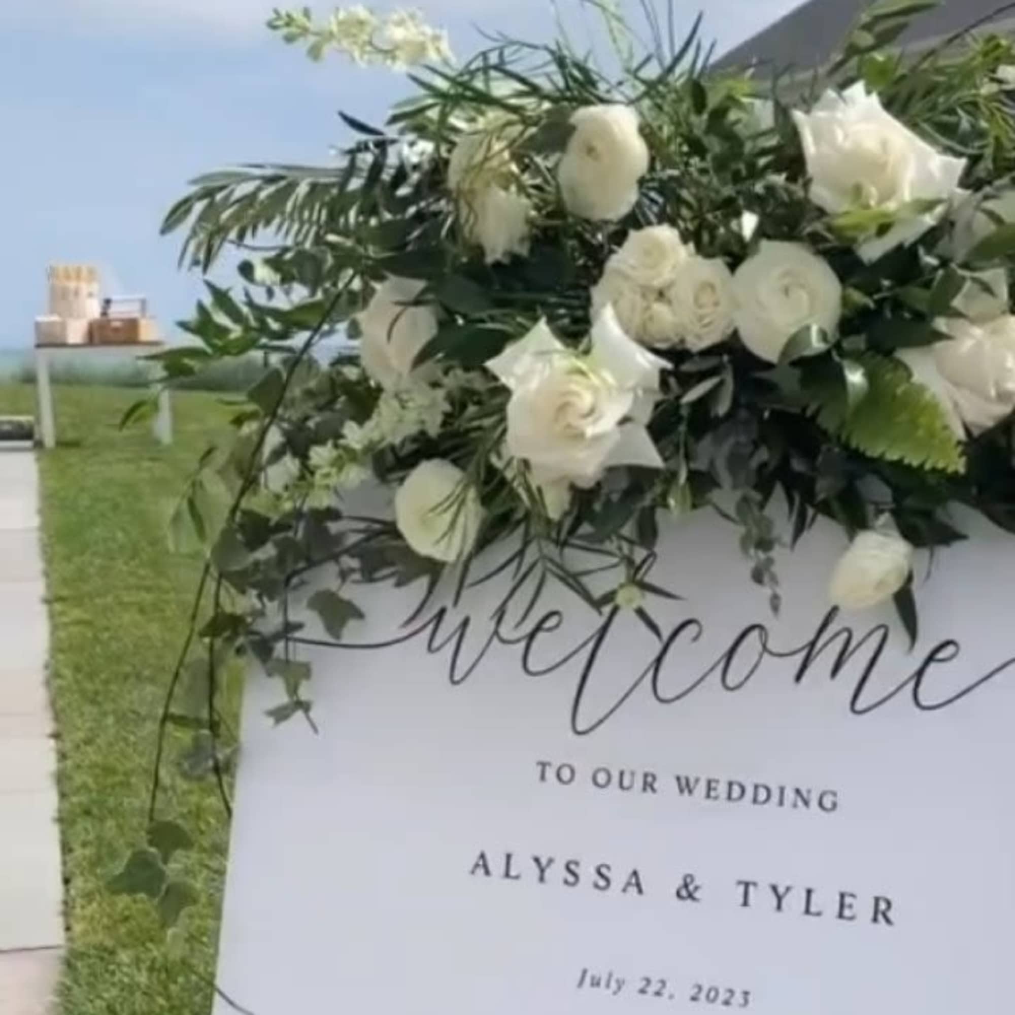 White floral arrangement on a wedding welcome sign