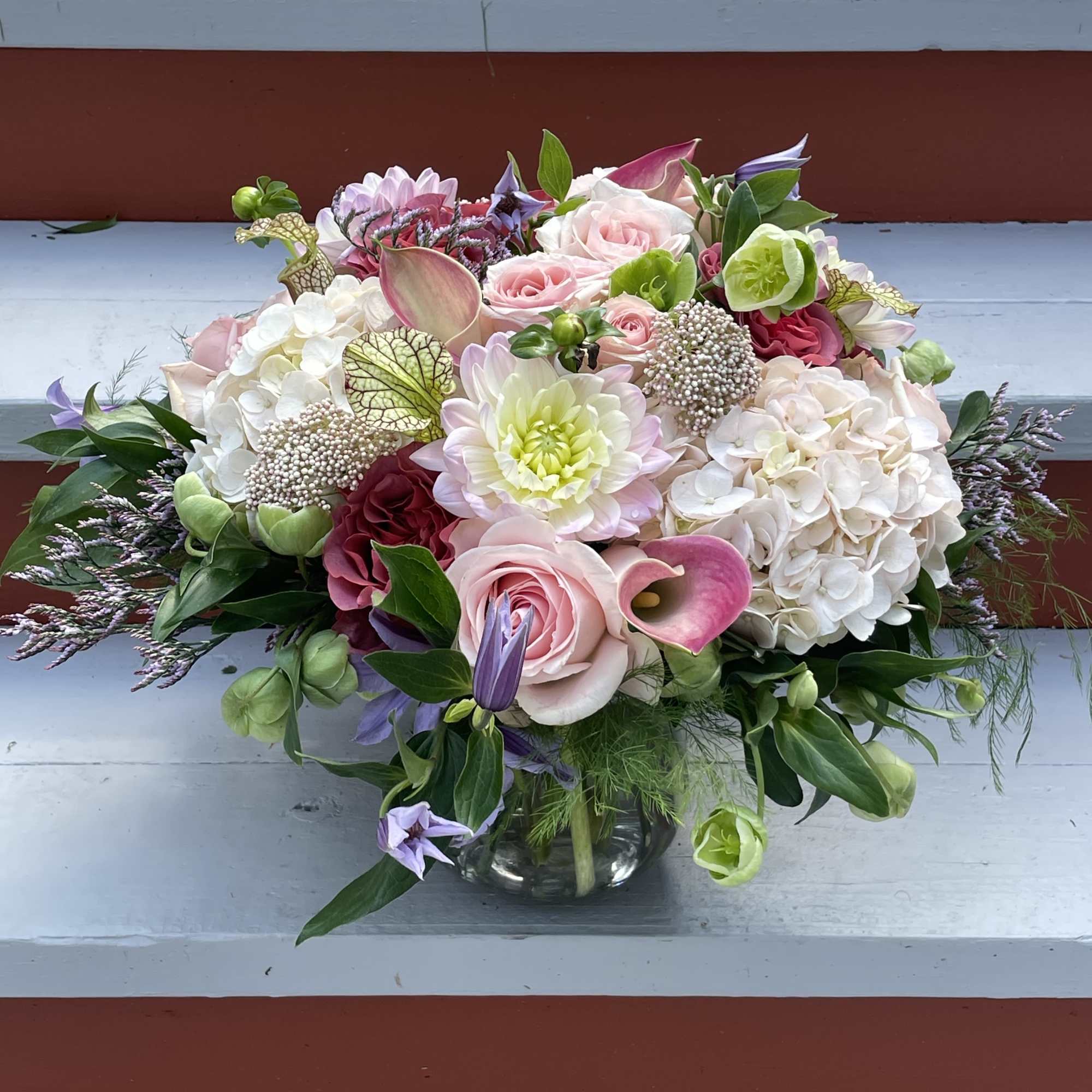 Mixed pink and white floral arrangement in a clear glass vase
