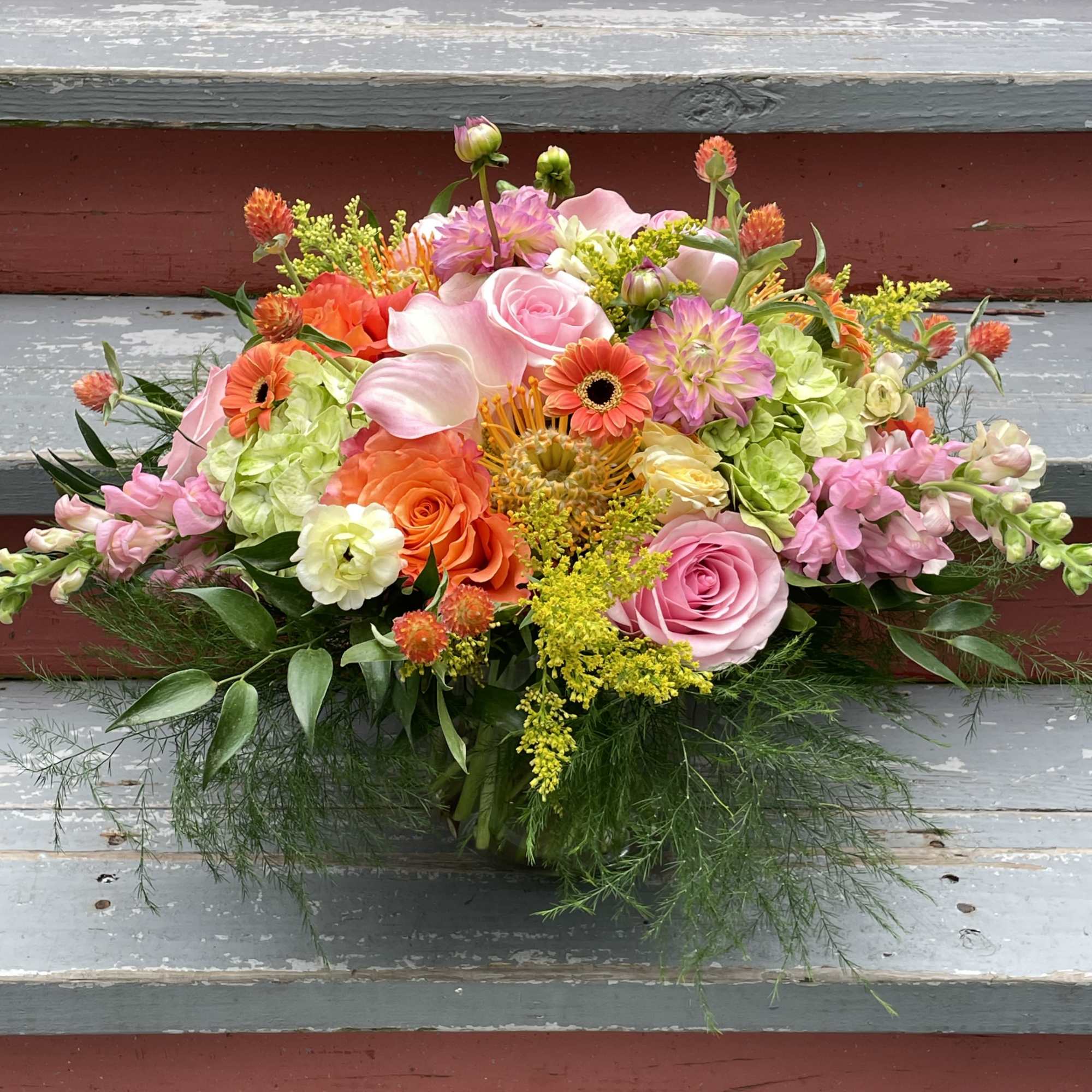 Mixed bouquet with pink roses, calla lilies, and orange blooms