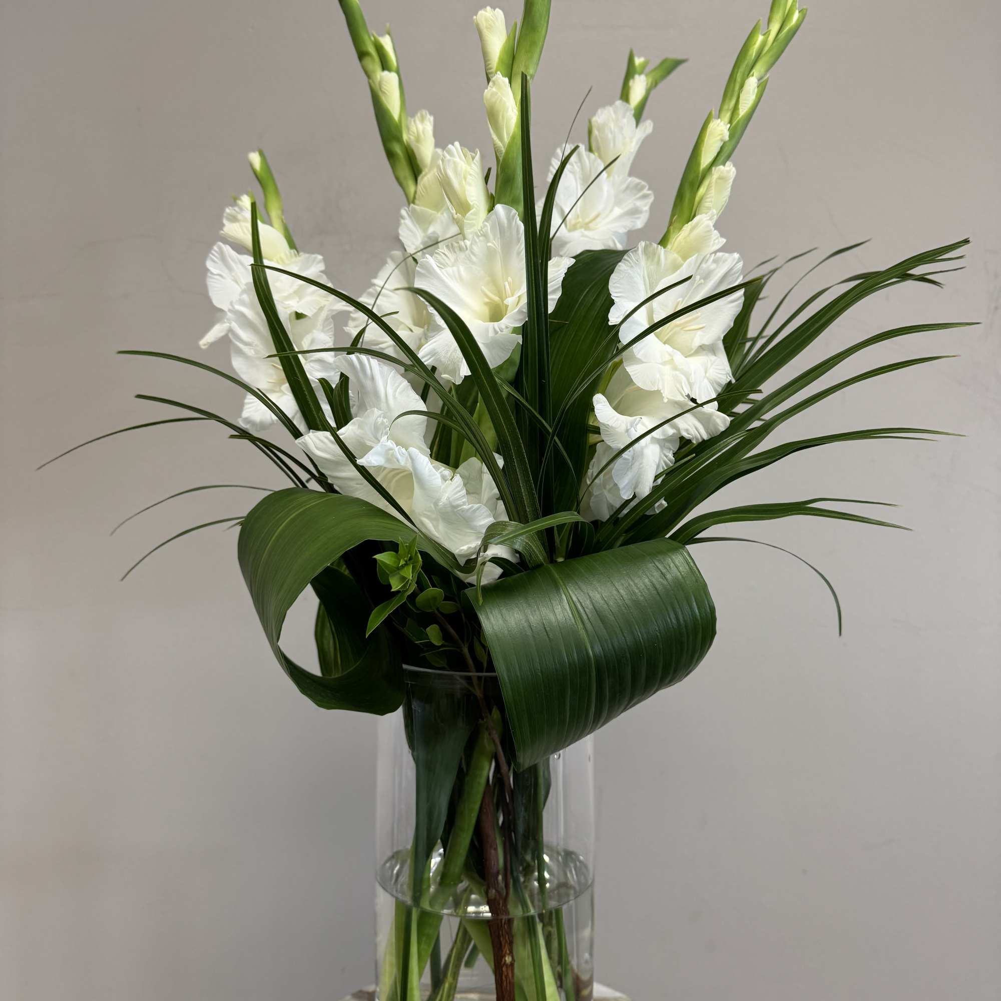 White gladiolus arrangement in a clear glass vase