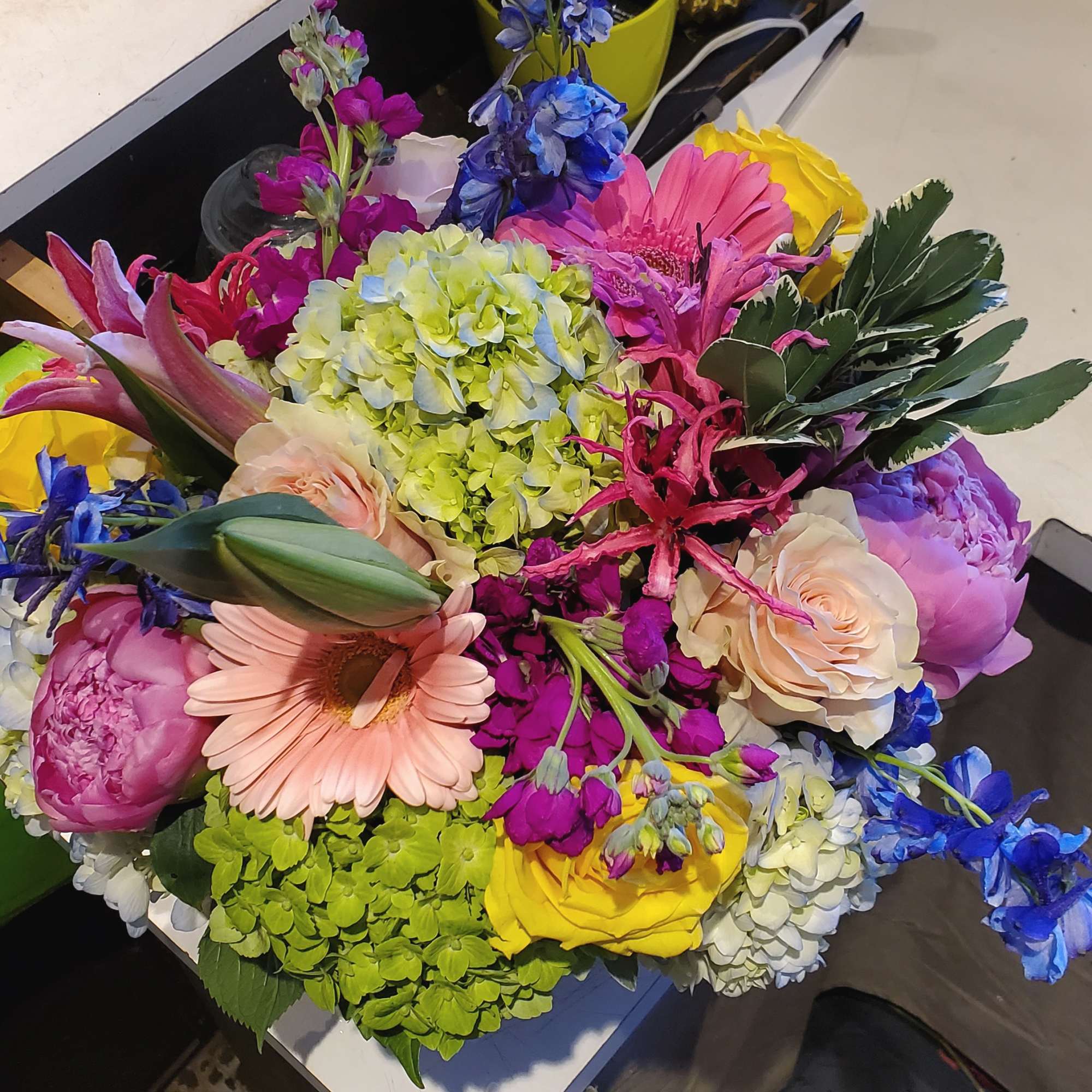 Colorful mixed bouquet with pink peonies, roses, gerbera daisy, hydrangeas, tulips and other bright blooms.
