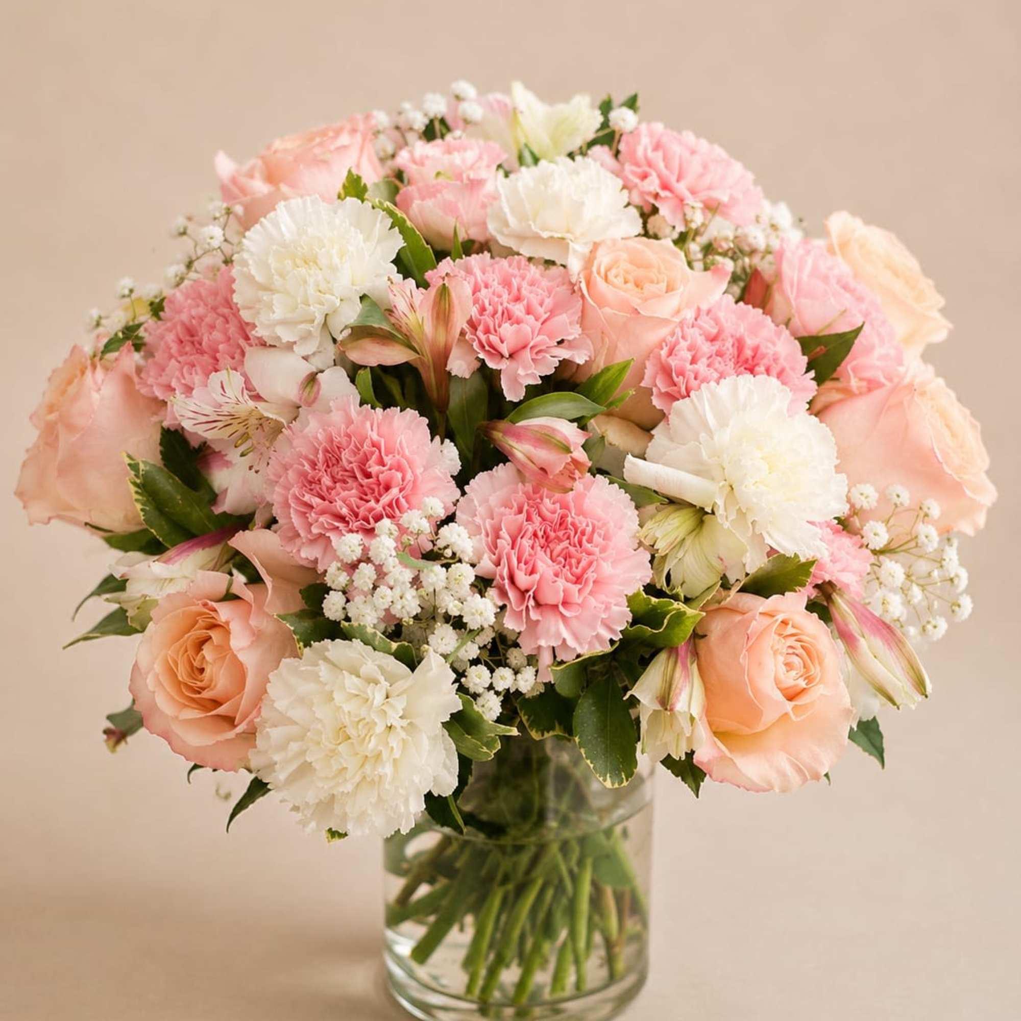 A soft cloud of blush pink and peach roses mingles with pink