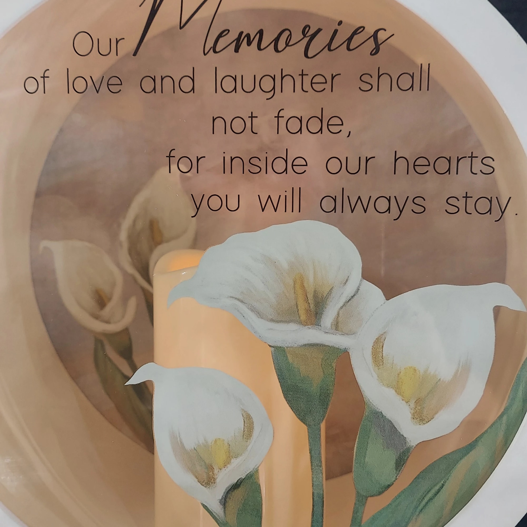 Memorial candle with white calla lilies and a remembrance message
