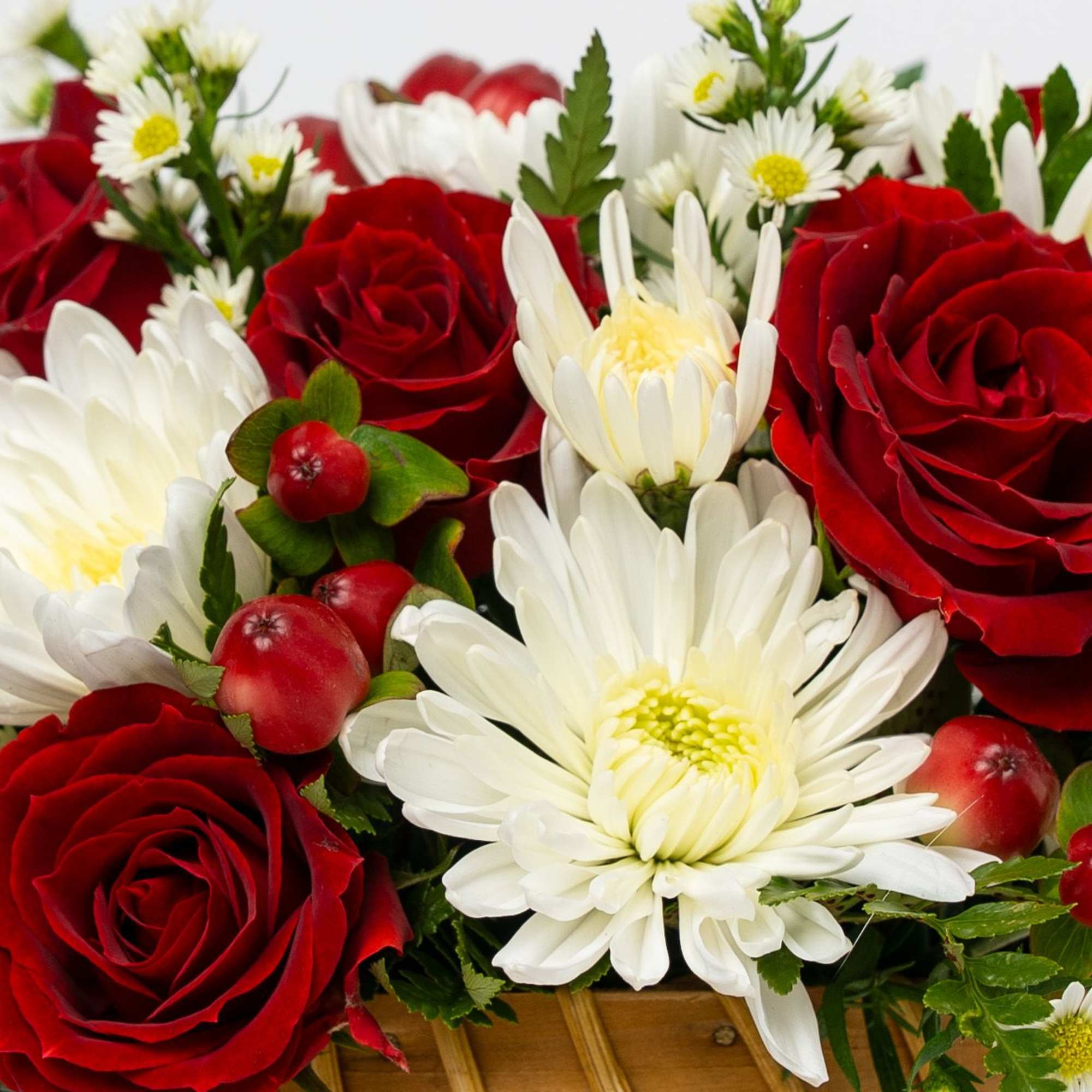 Red roses and white daisies in a woven basket