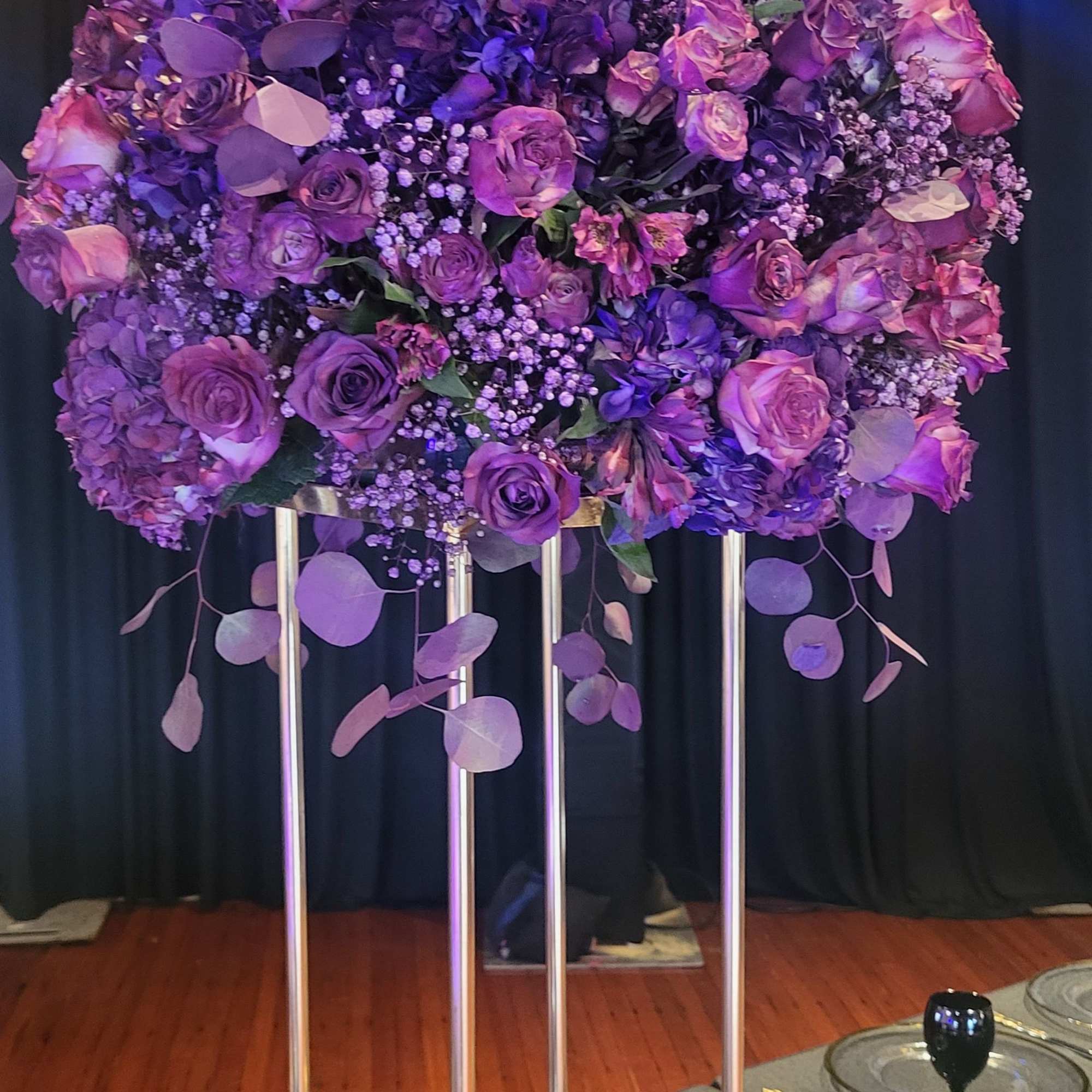 A lush, elevated centerpiece in rich purple tones-this flower arrangement for special
