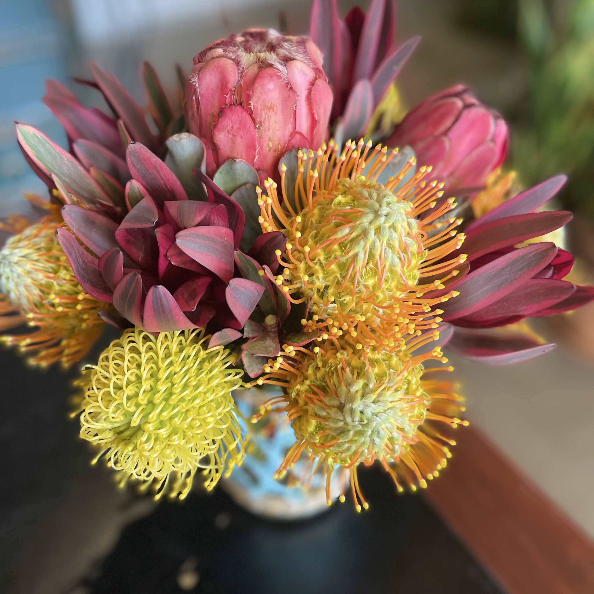 Bouquet of pink and yellow protea flowers in a vase