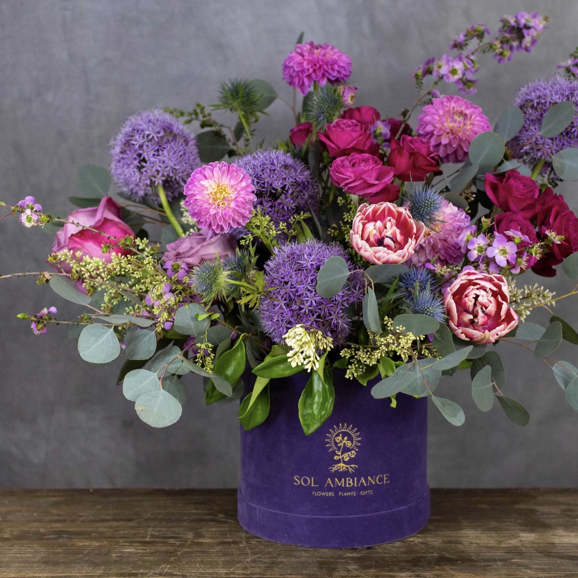 Purple and pink mixed bouquet in a purple hat box