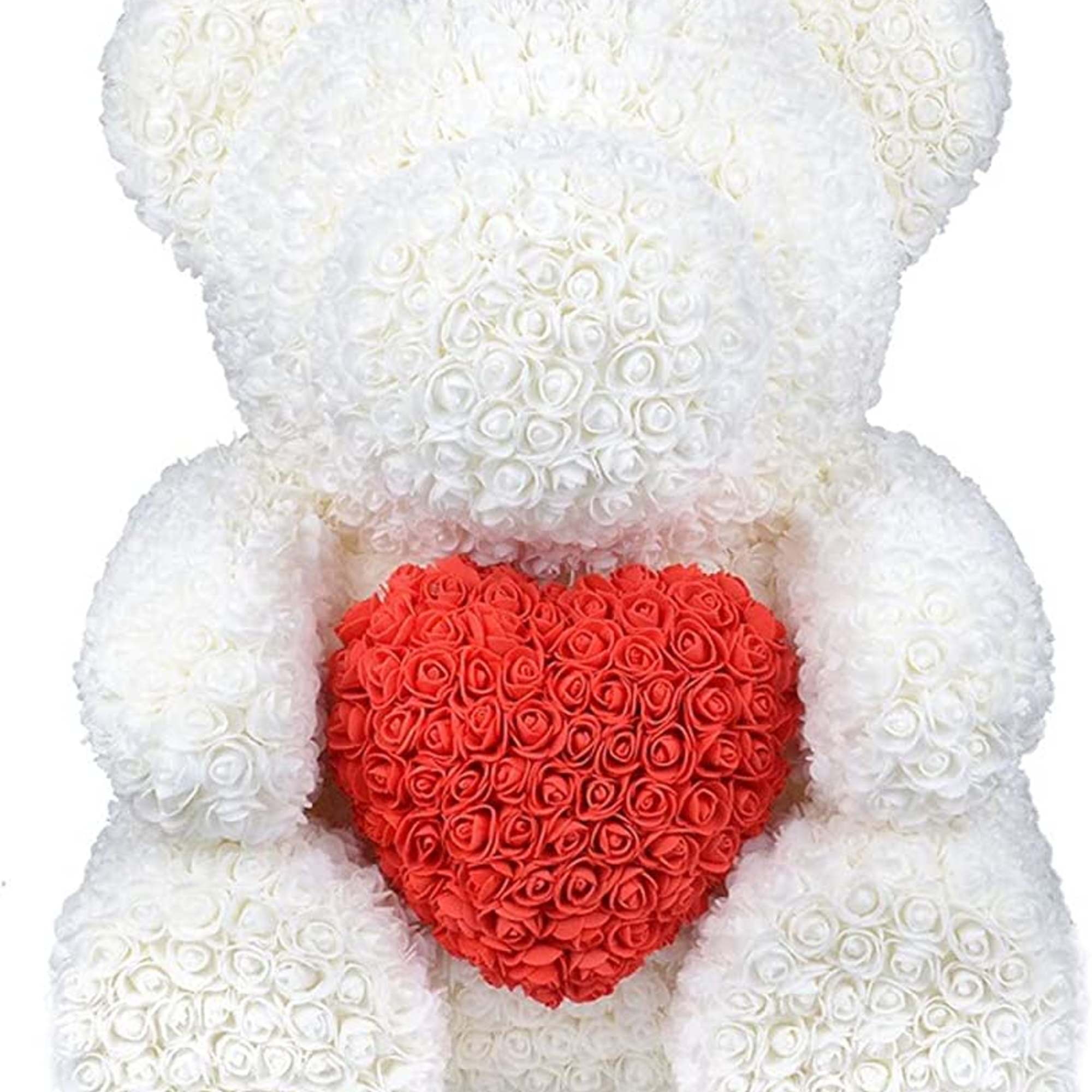 White teddy bear holding a red heart made of roses