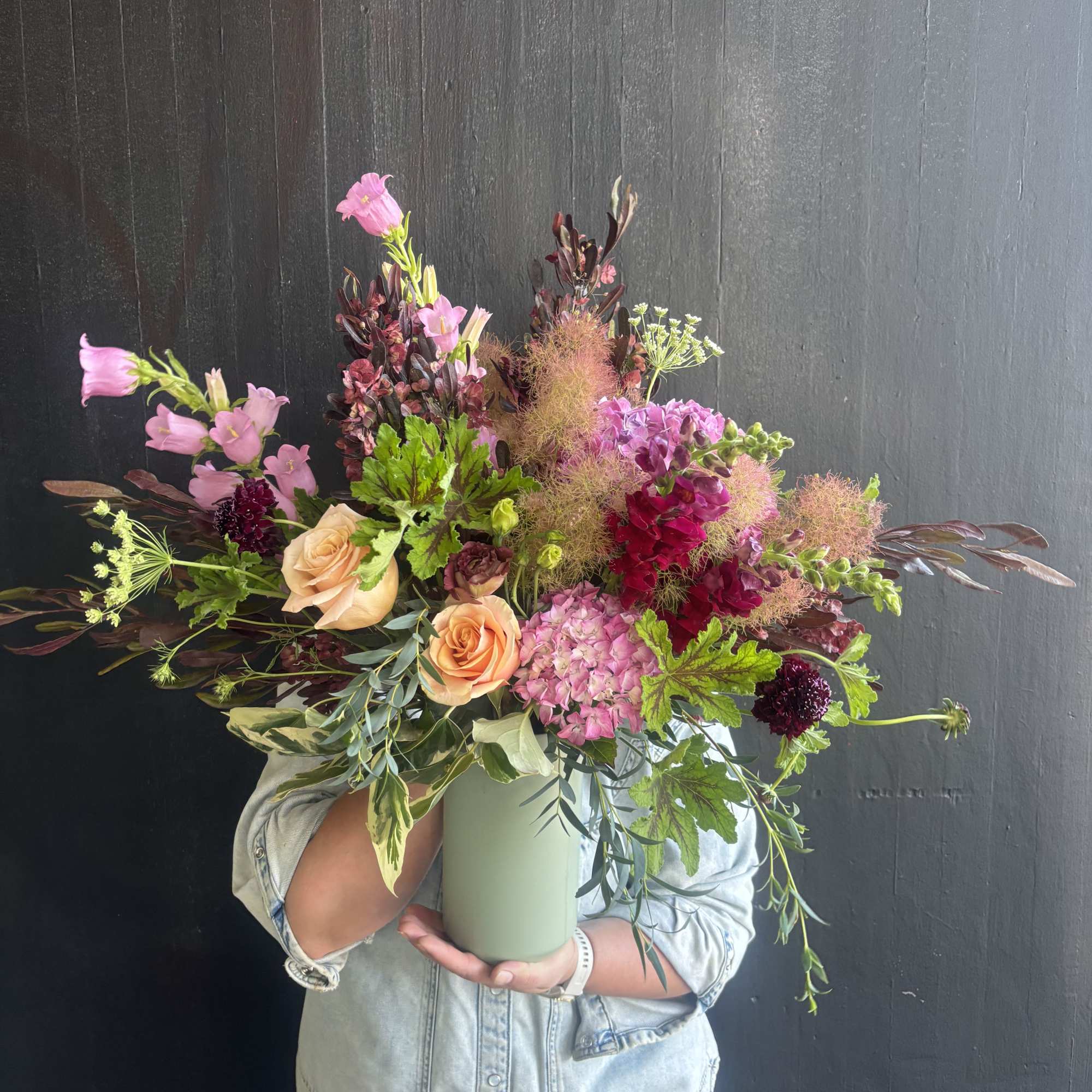 Weekly seasonal arrangement that showcases local flowers like smoke bush, geranium, and