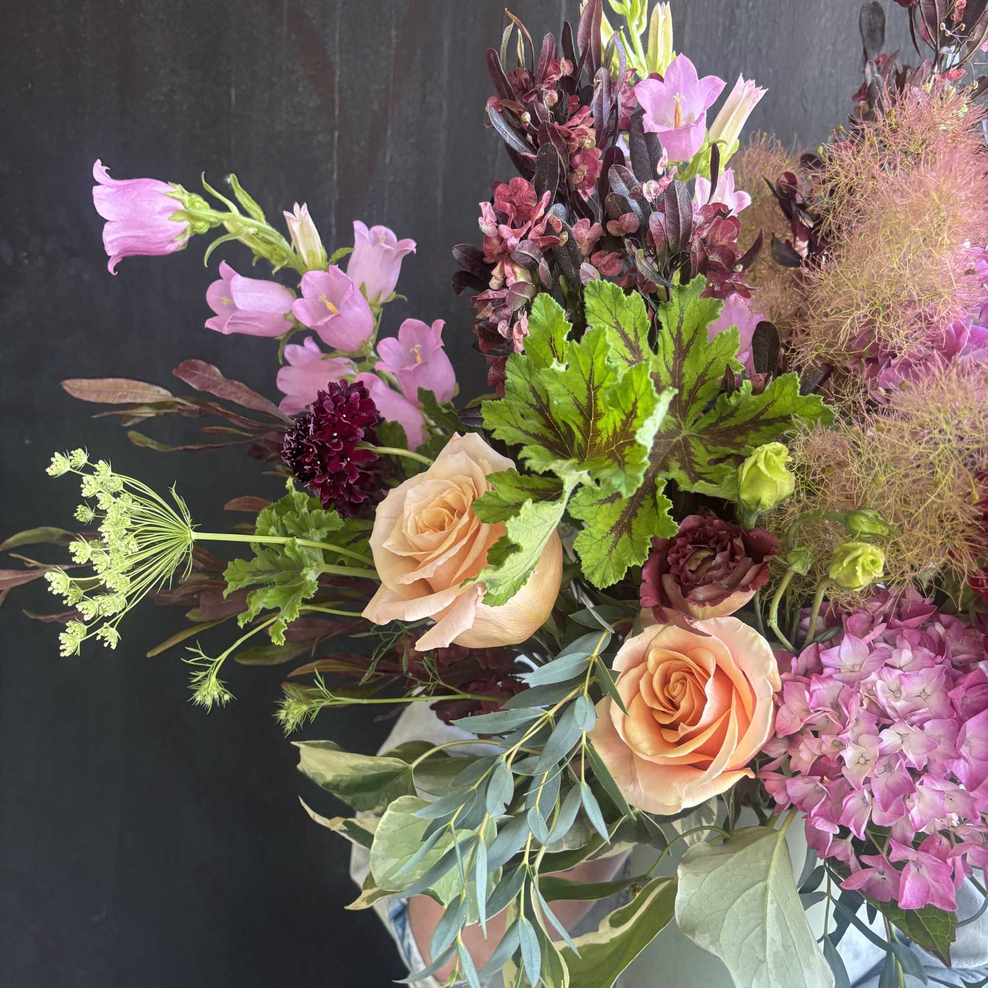 Weekly seasonal arrangement that showcases local flowers like smoke bush, geranium, and