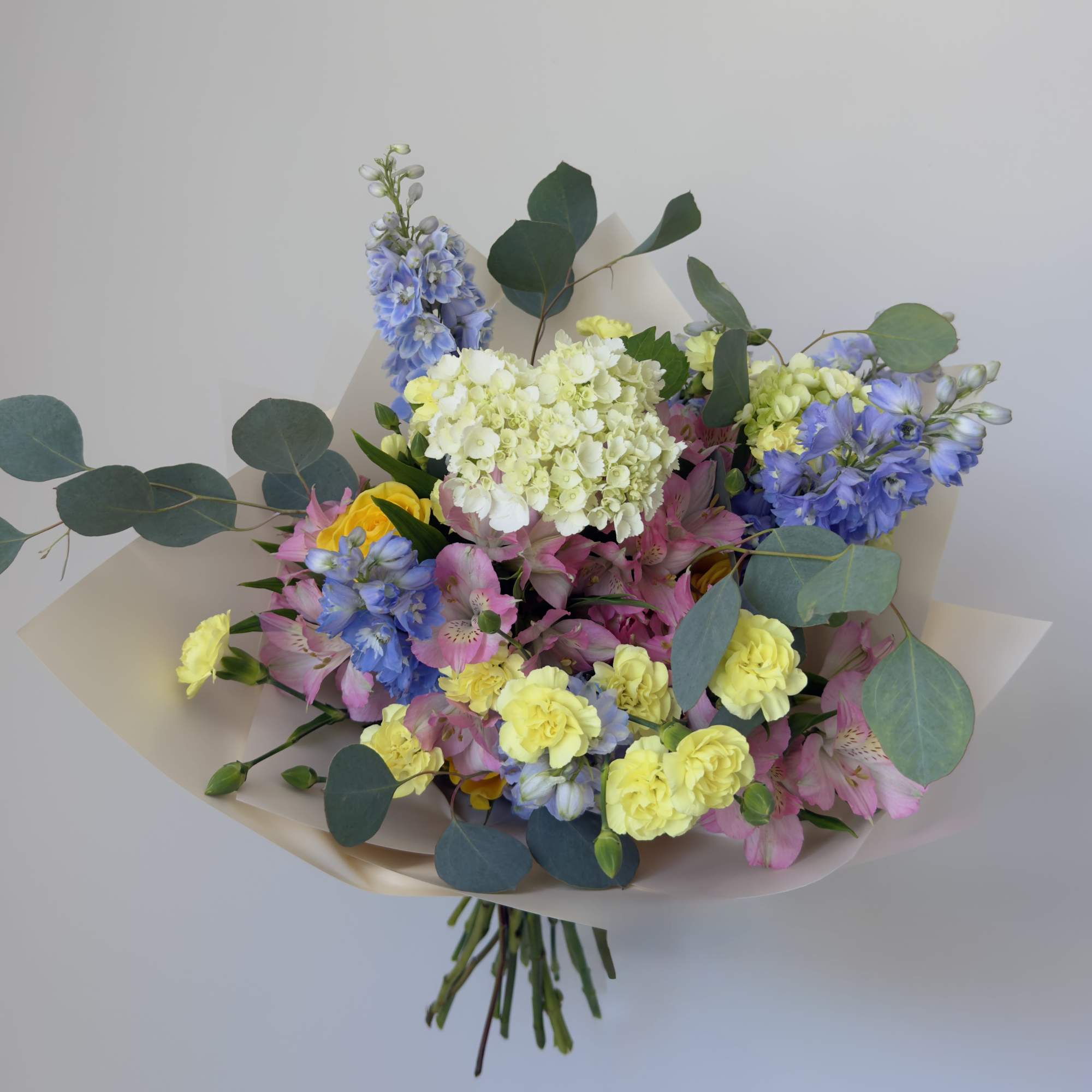 A charming bouquet of seasonal blooms in soft pastel shades, thoughtfully arranged