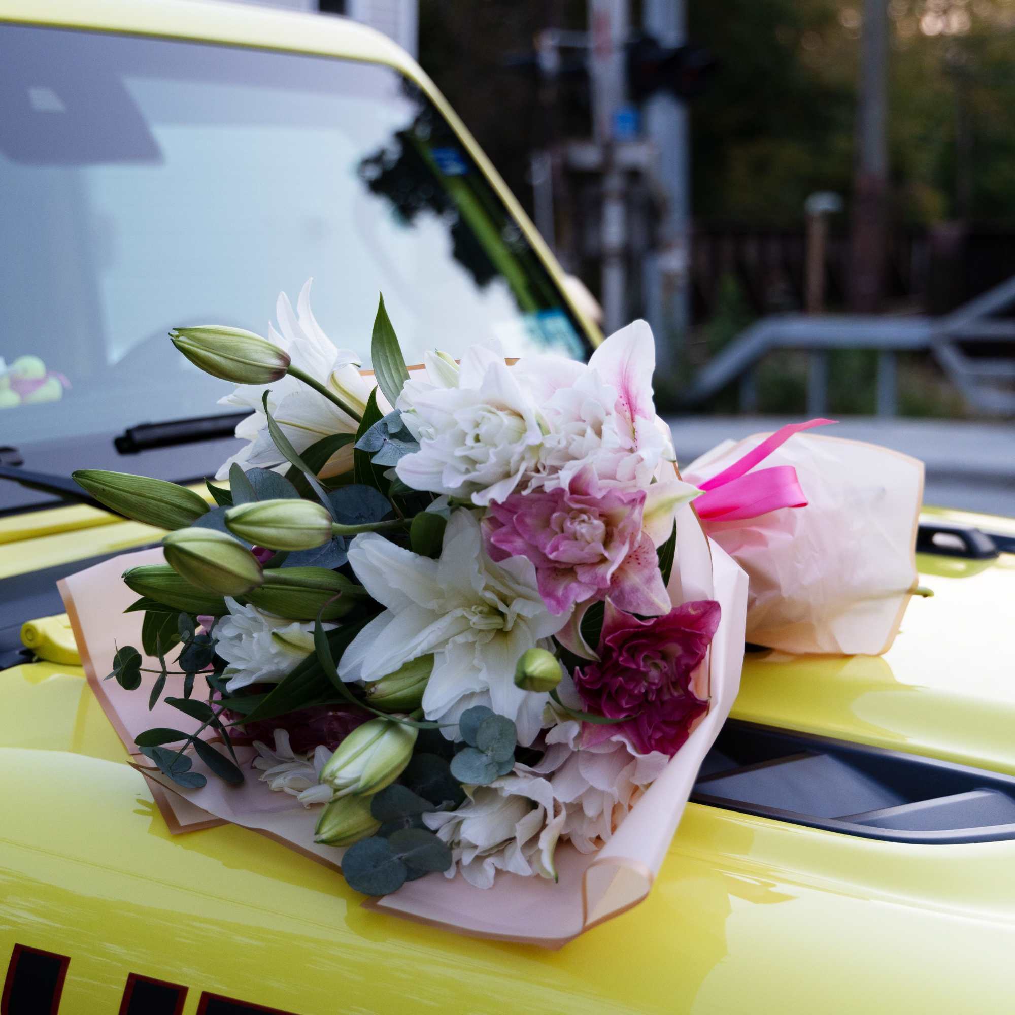 Bouquet of white and pink lilies wrapped in pale paper