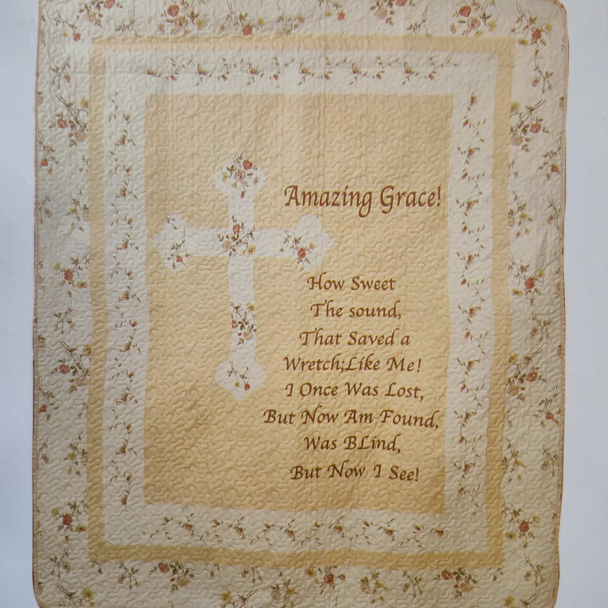 A soft cream quilted throw embroidered with a printed cross and the