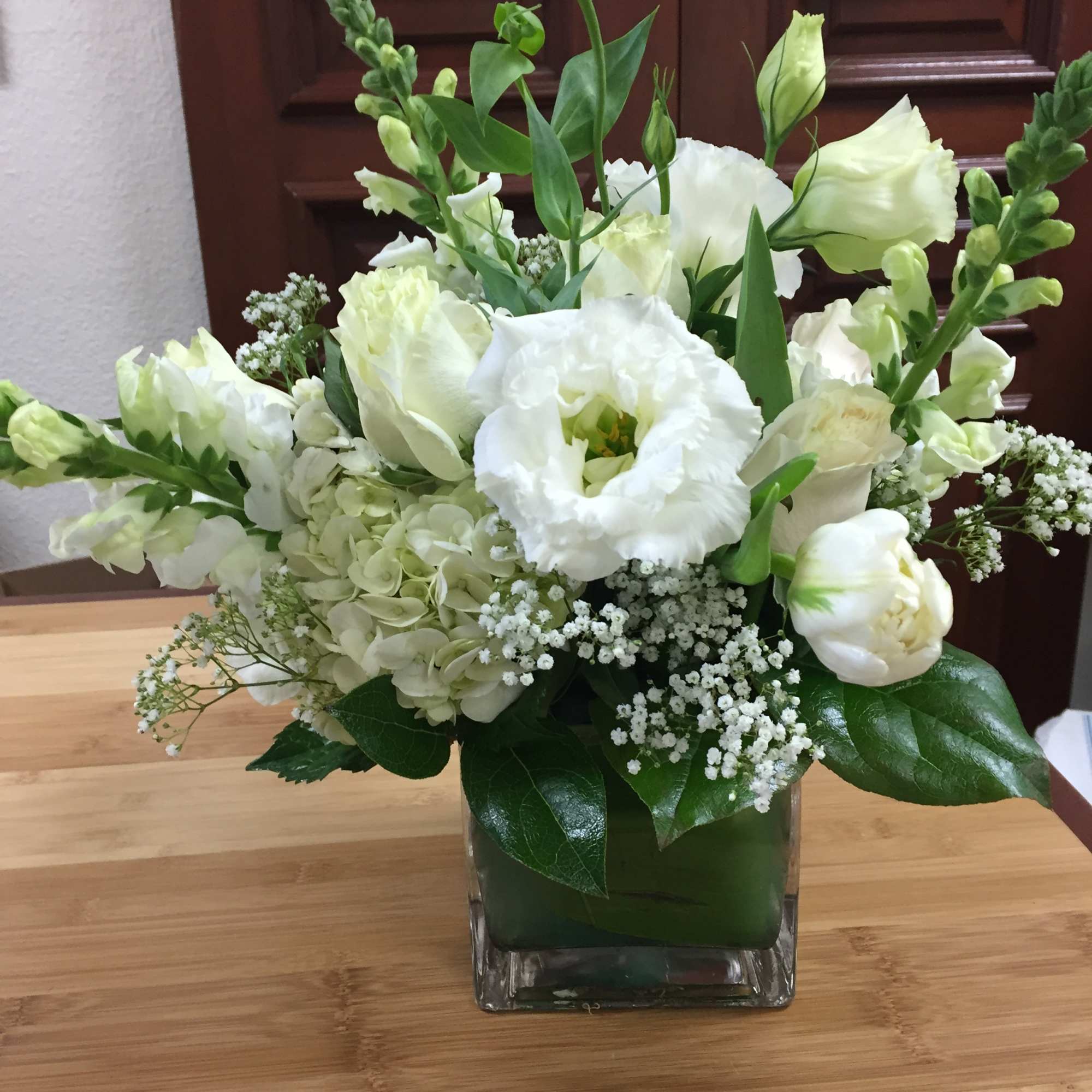 White floral arrangement in a square glass vase