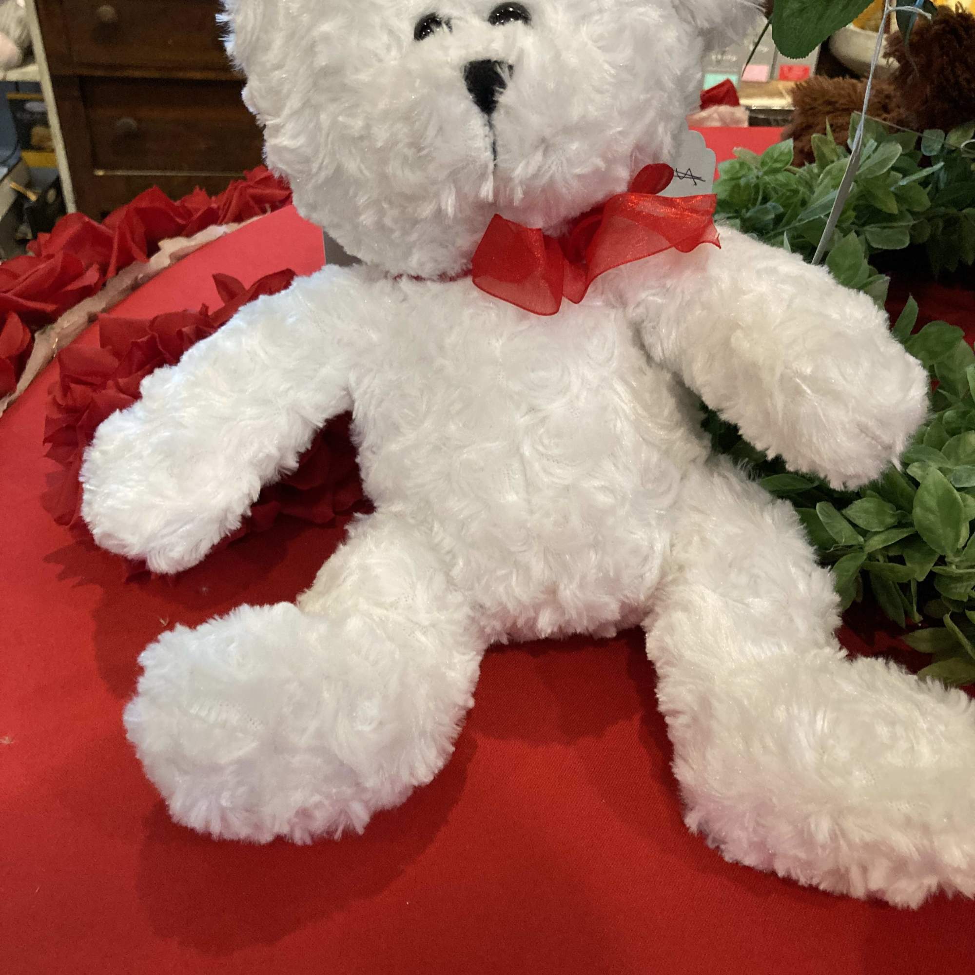 White plush teddy bear with a red ribbon bow