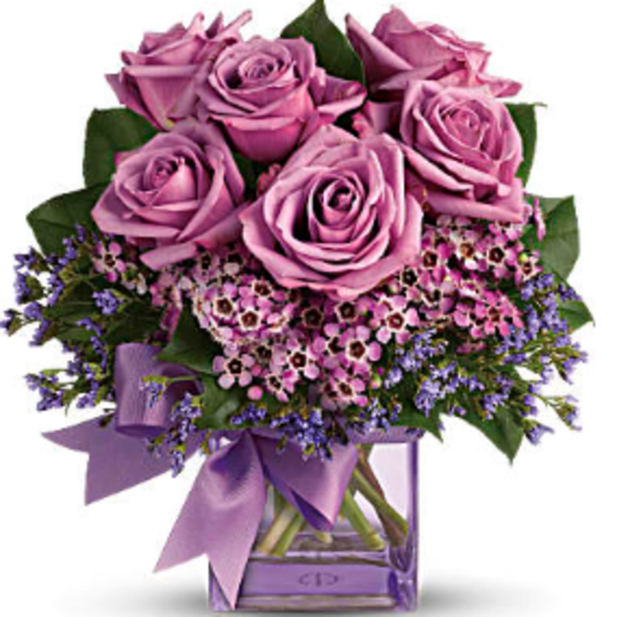 Pink roses in a clear glass vase with a purple ribbon