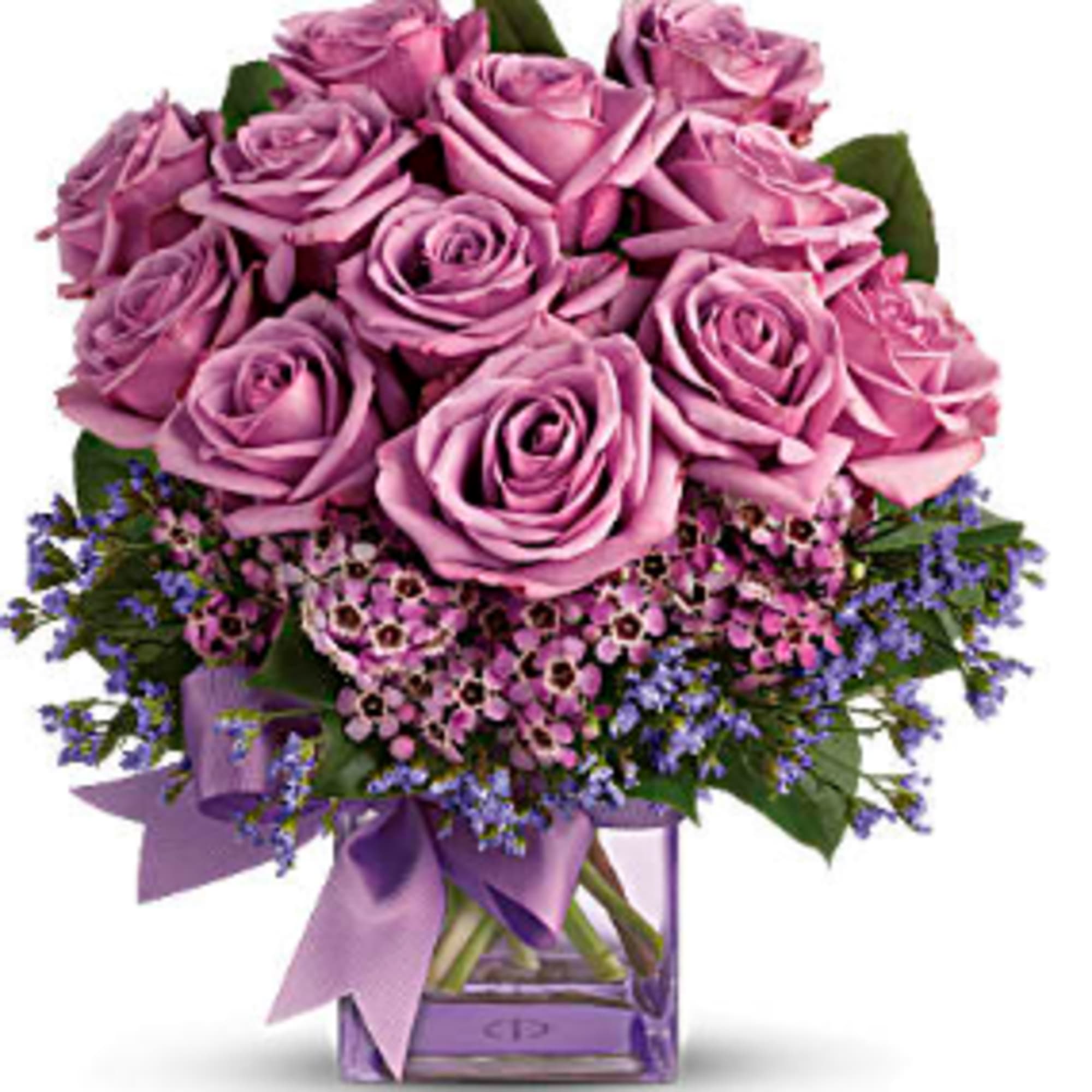 Lavender roses in a square glass vase with a purple ribbon
