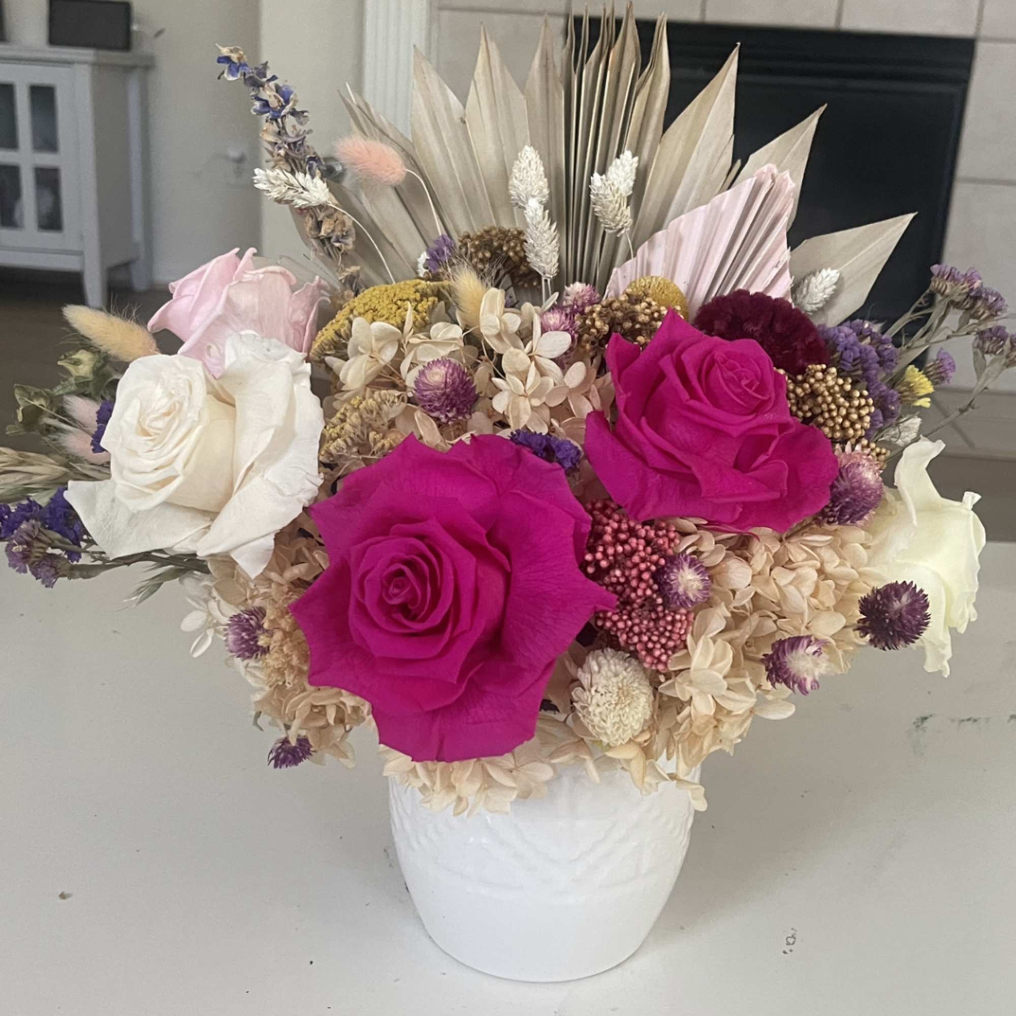 Bouquet of hot pink and white roses in a white vase